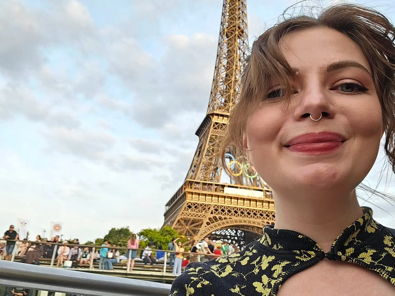 A woman poses in front of the Effiel Tower.