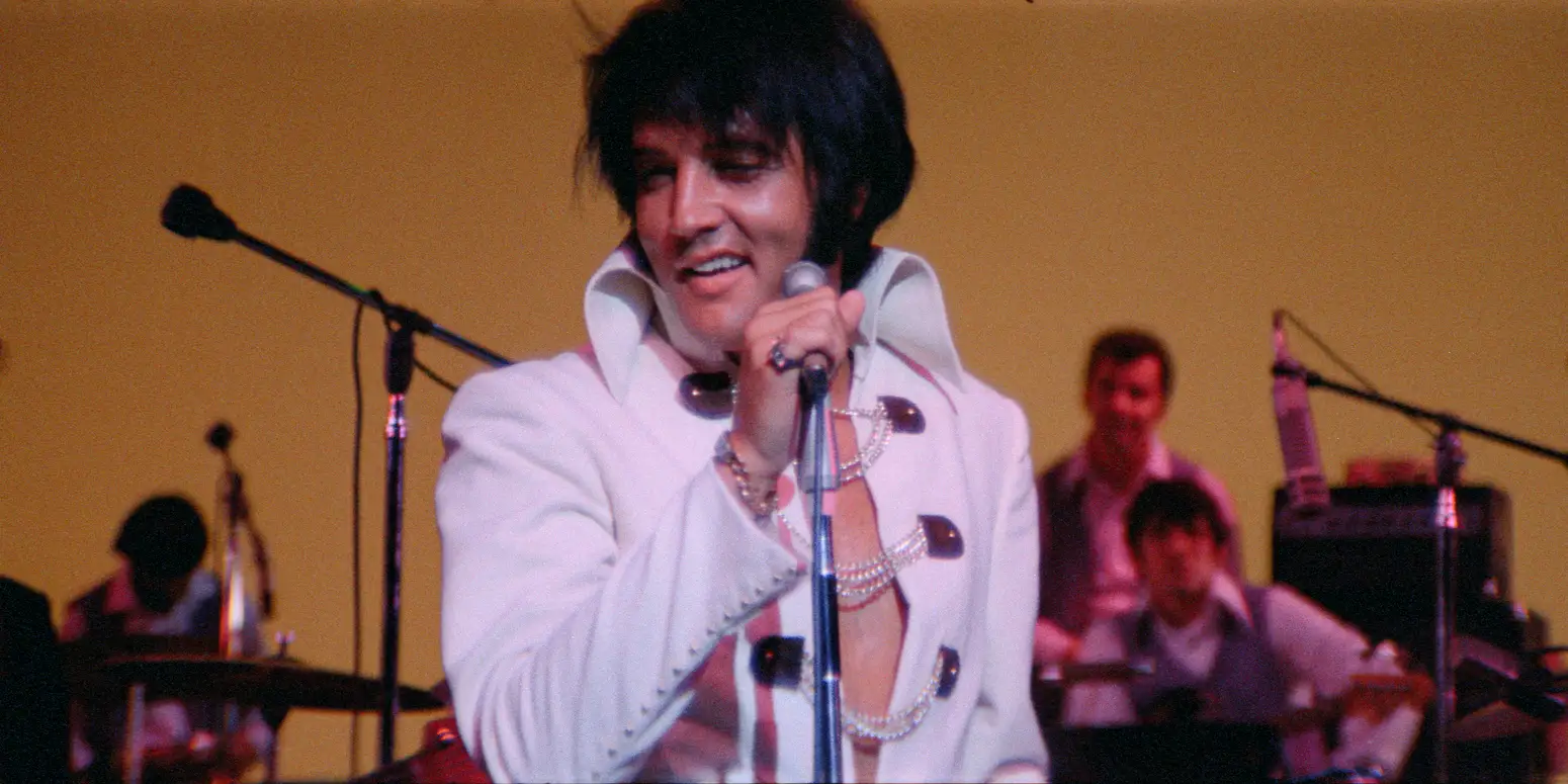 Elvis holding a microphone and smiling
