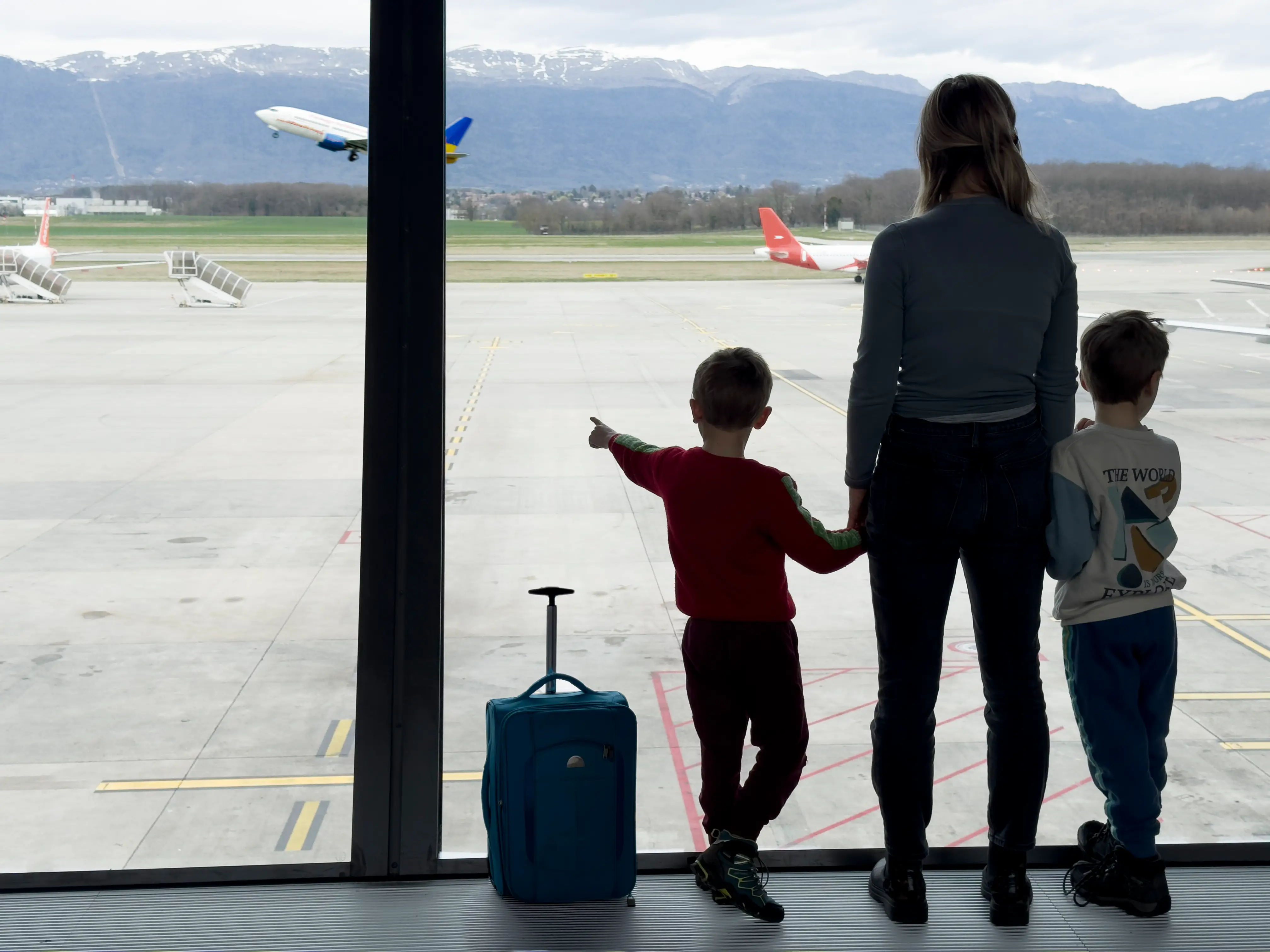 Family of three at airport looking at aircraft