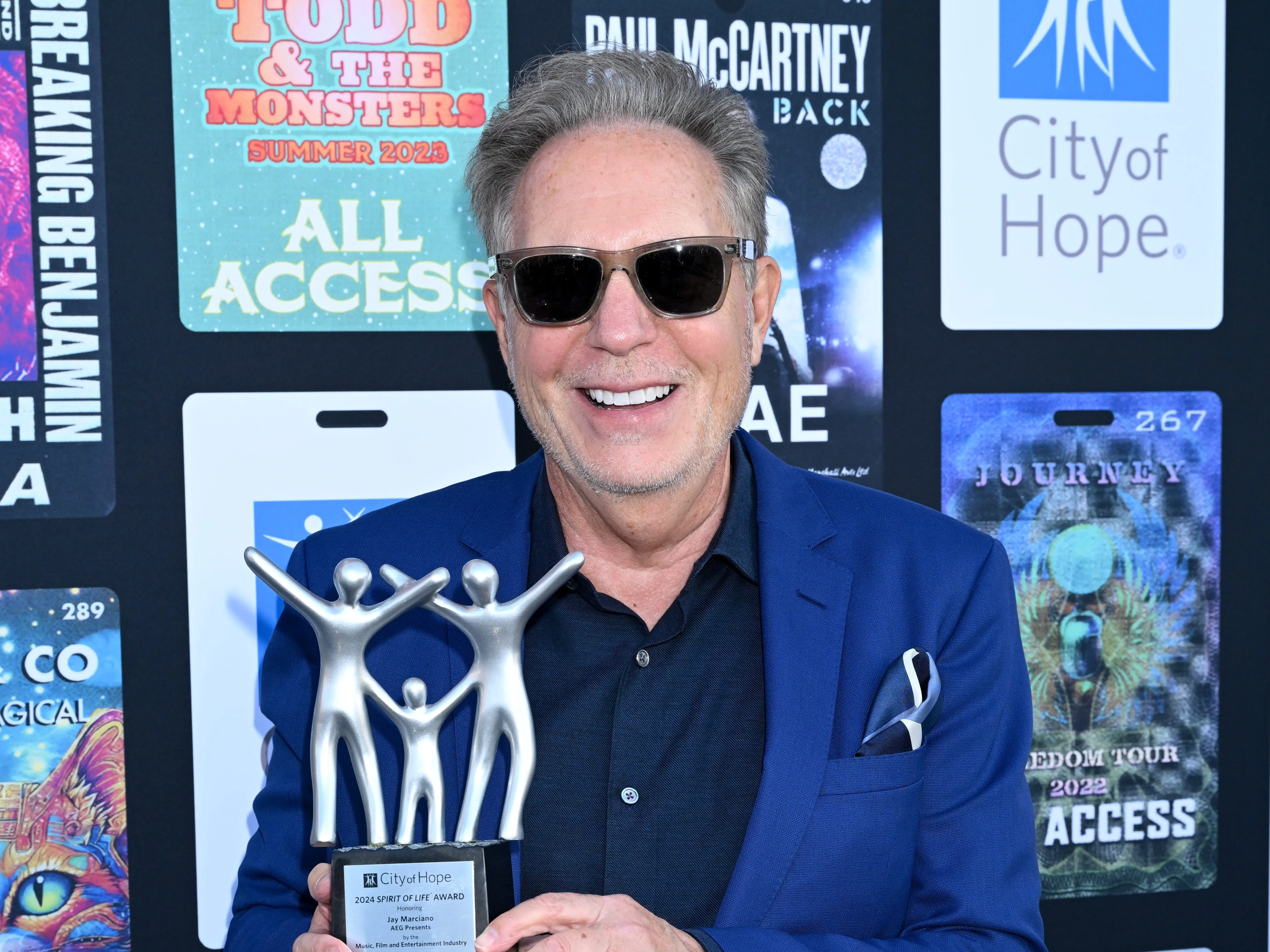 Jay Marciano holds an award in 2024