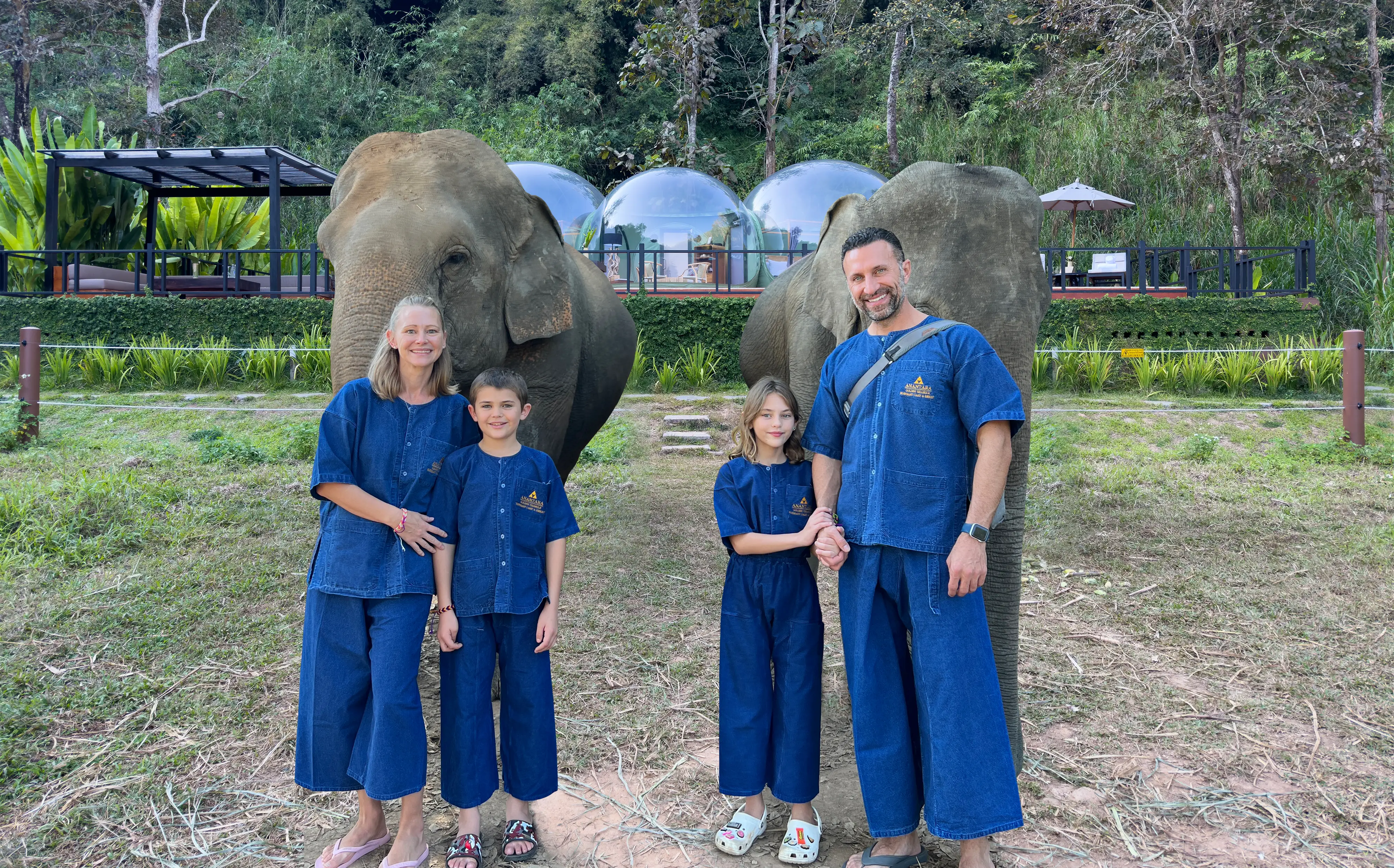 Family of four posing with elephants