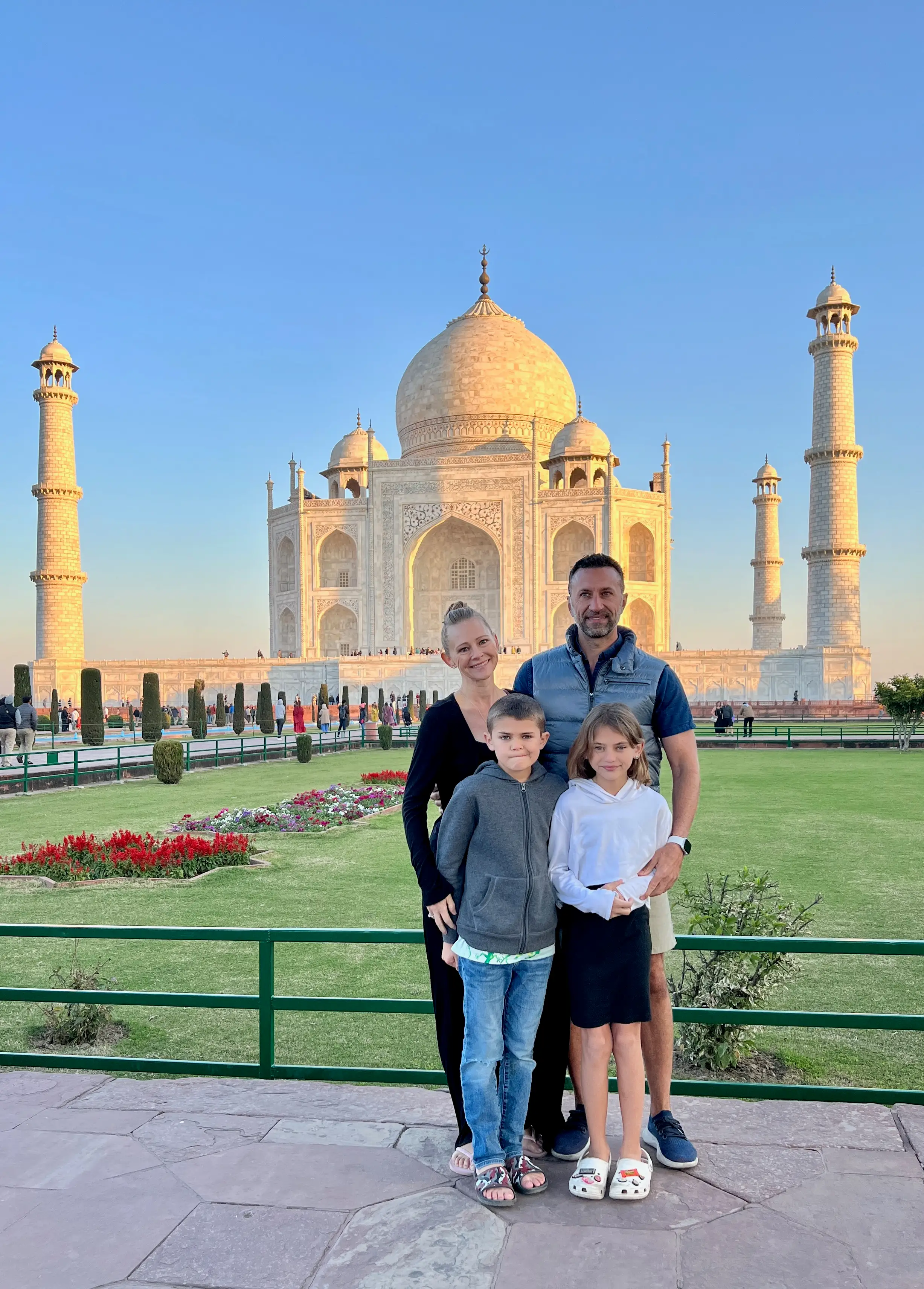 Family of four smiling in front of temple-like buildings