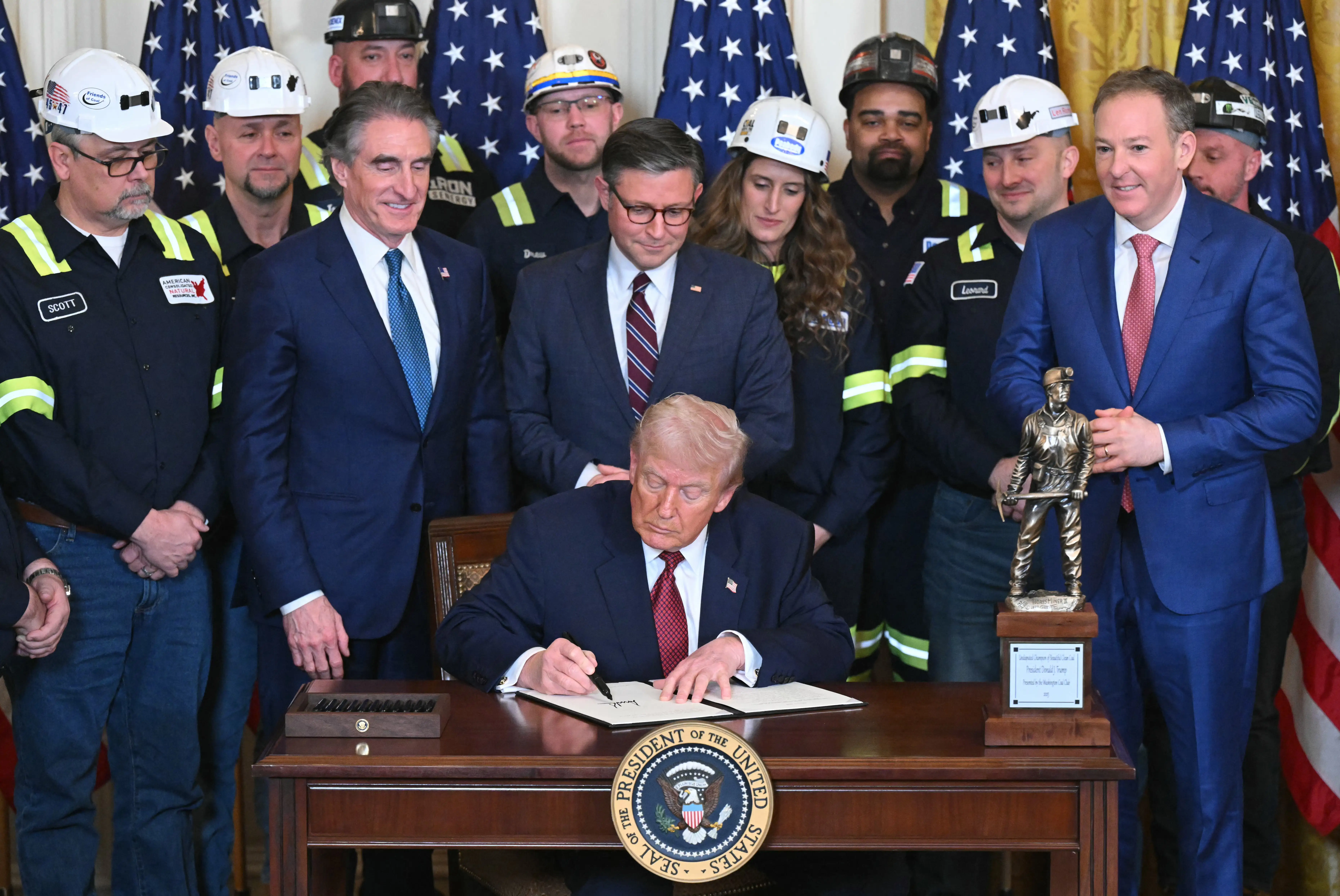 US Secretary of the Interior Doug Burgum, House Speaker Mike Johnson and EPA Administrator Lee Zeldin watch as US President Donald Trump sign an executive order directing the military to purchase electricity from coal-fired power plants during a 