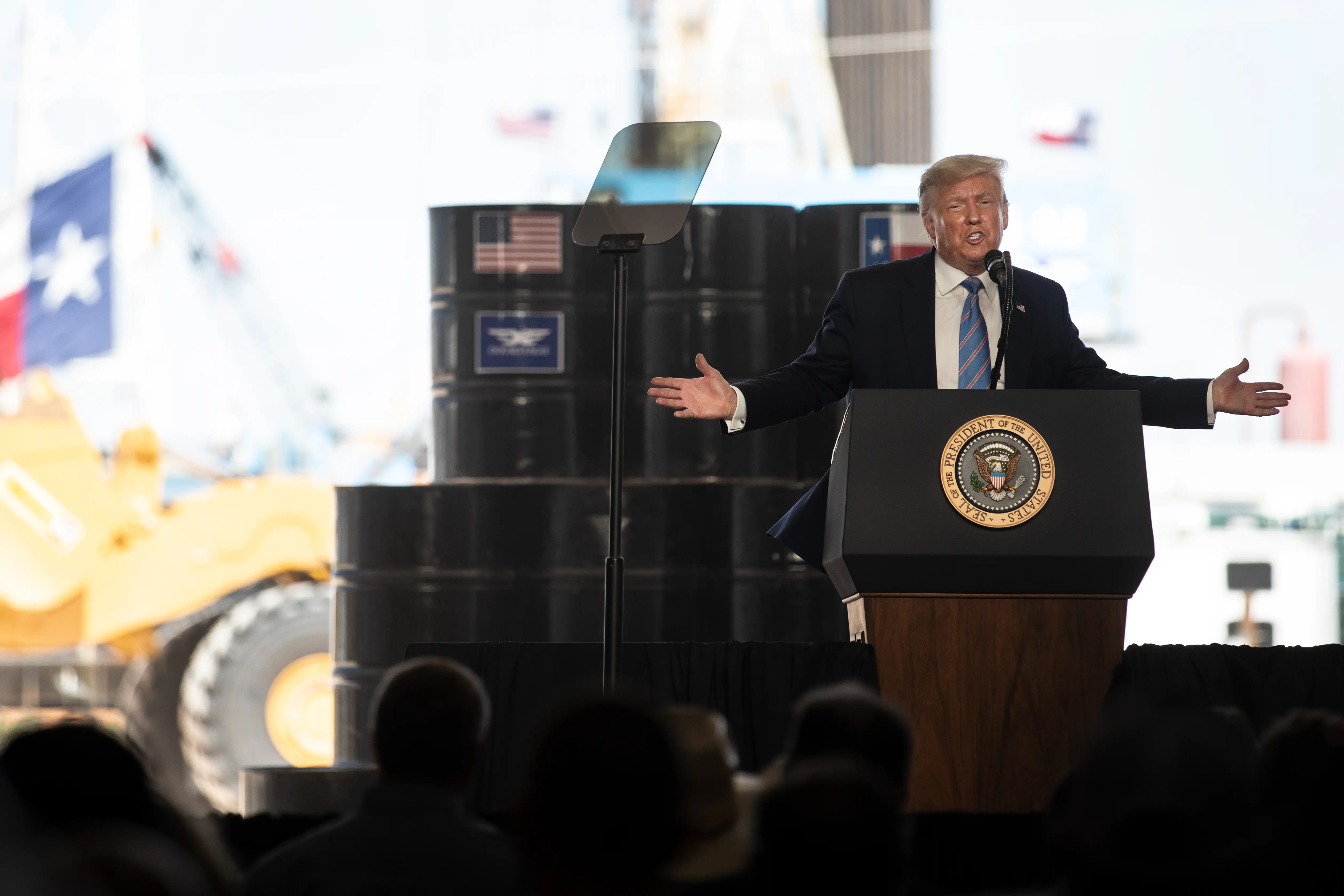President Trump speaking in front of oil barrels