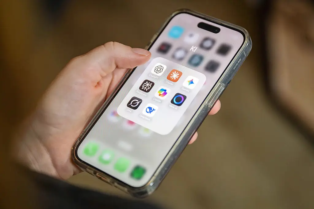 Several AI applications can be seen on a smartphone screen, including ChatGPT, Claude, Gemini, Perplexity, Microsoft Copilot, Meta AI, Grok and DeepSeek.