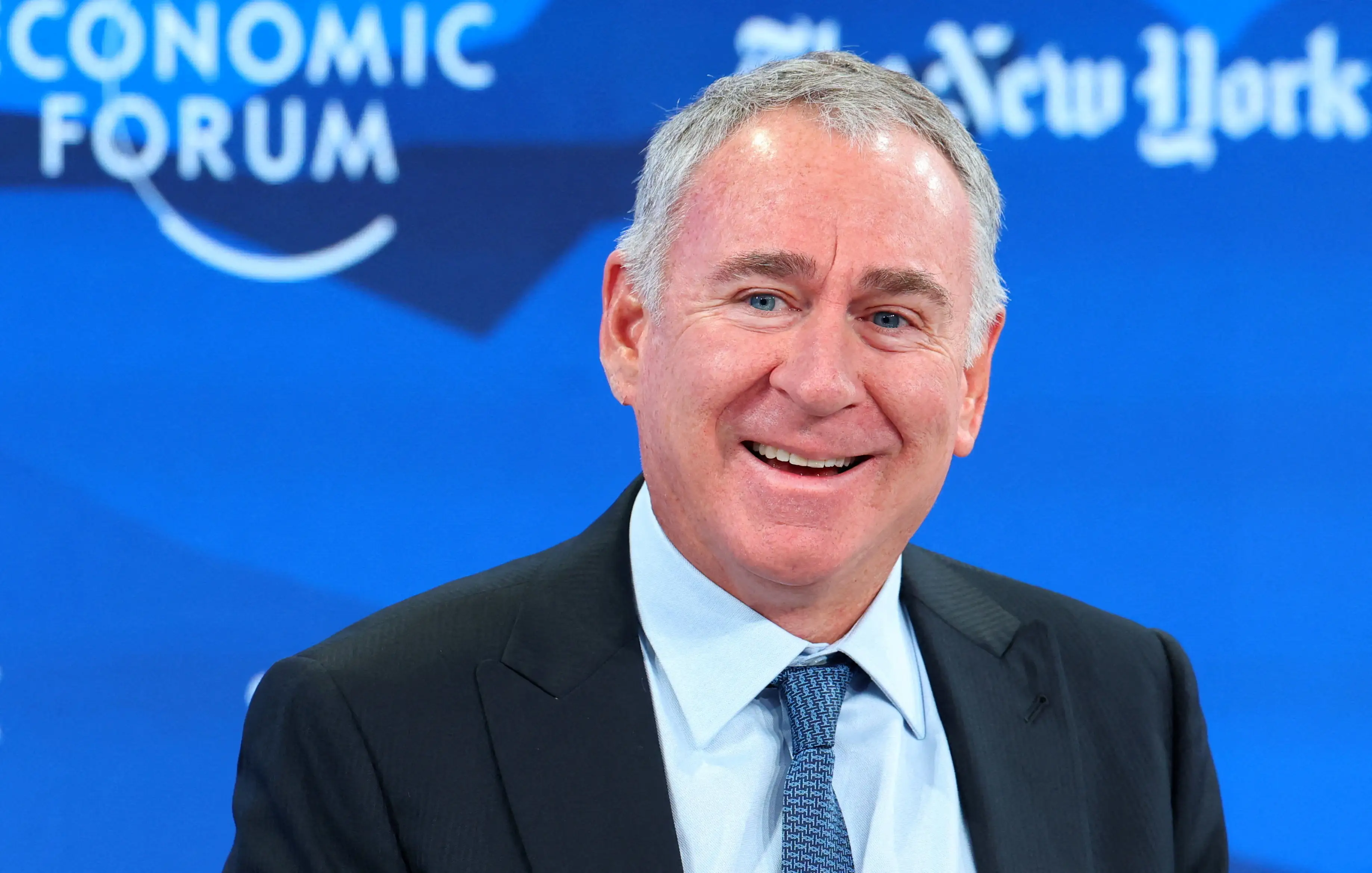 Ken Griffin smiles in a dark suit on stage