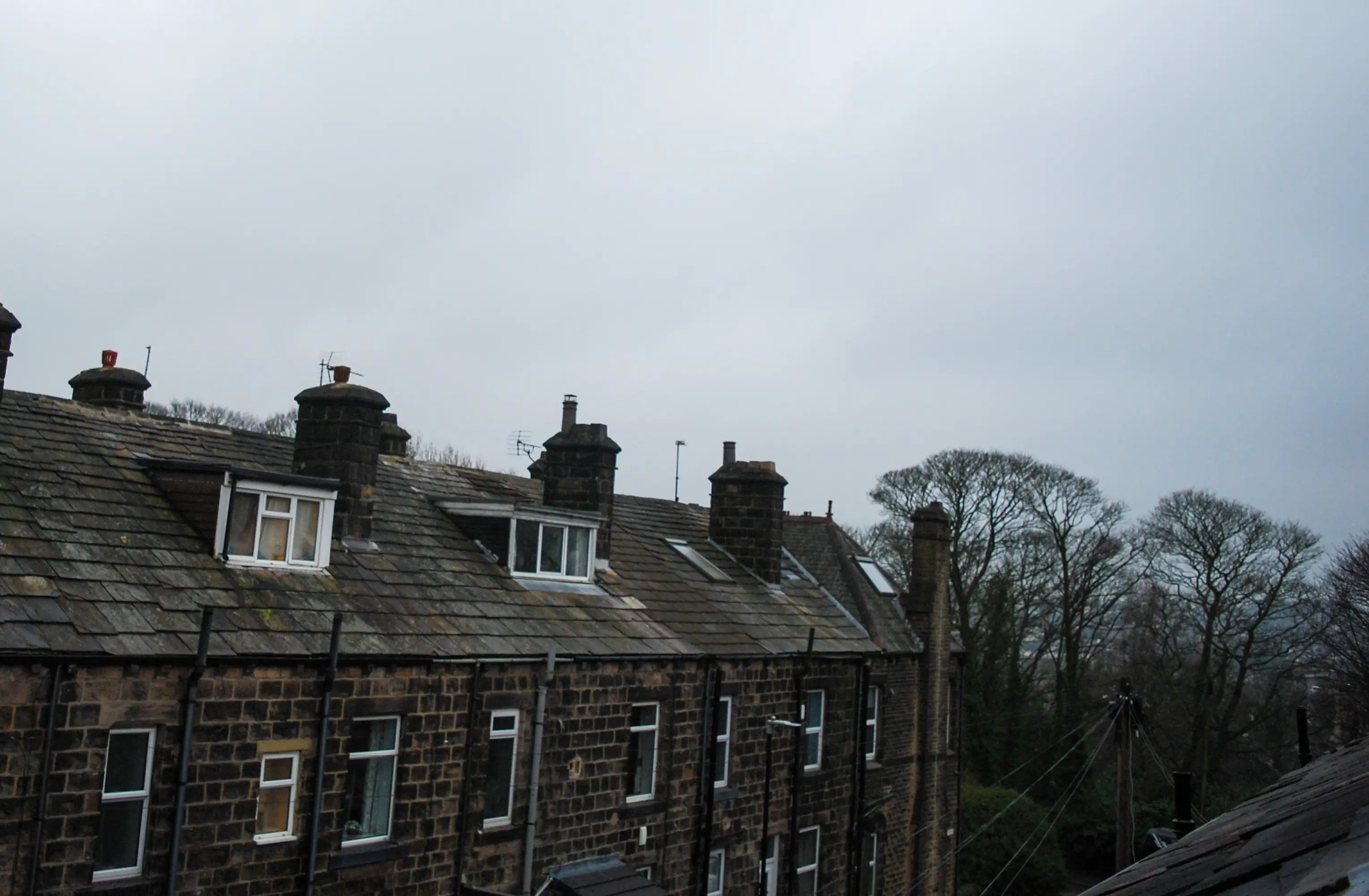 Aerial view of row of houses under cloudy sky
