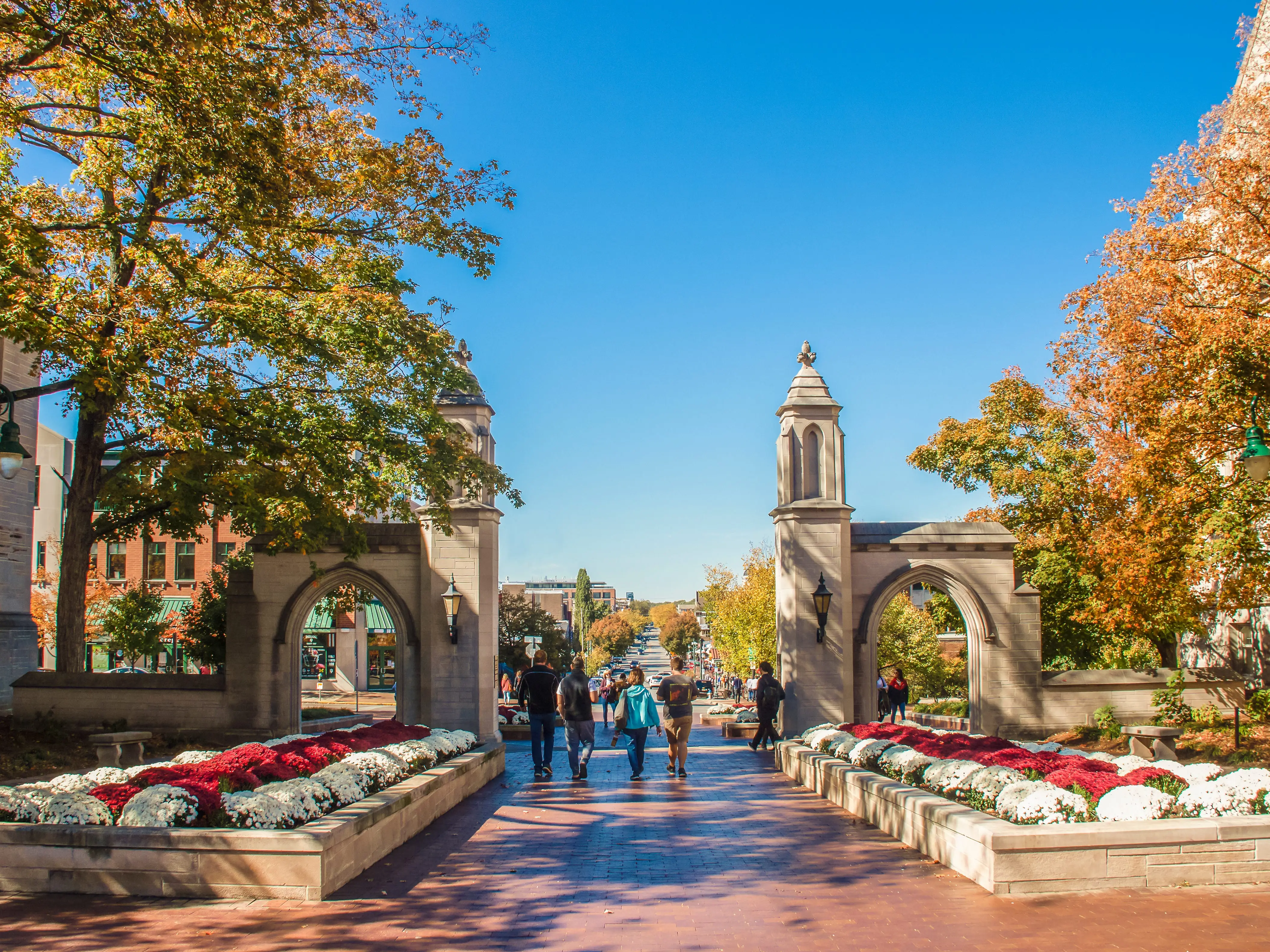 University of Indiana - Family walks with college student out main gates of campus down into the town during Fall Break weekend