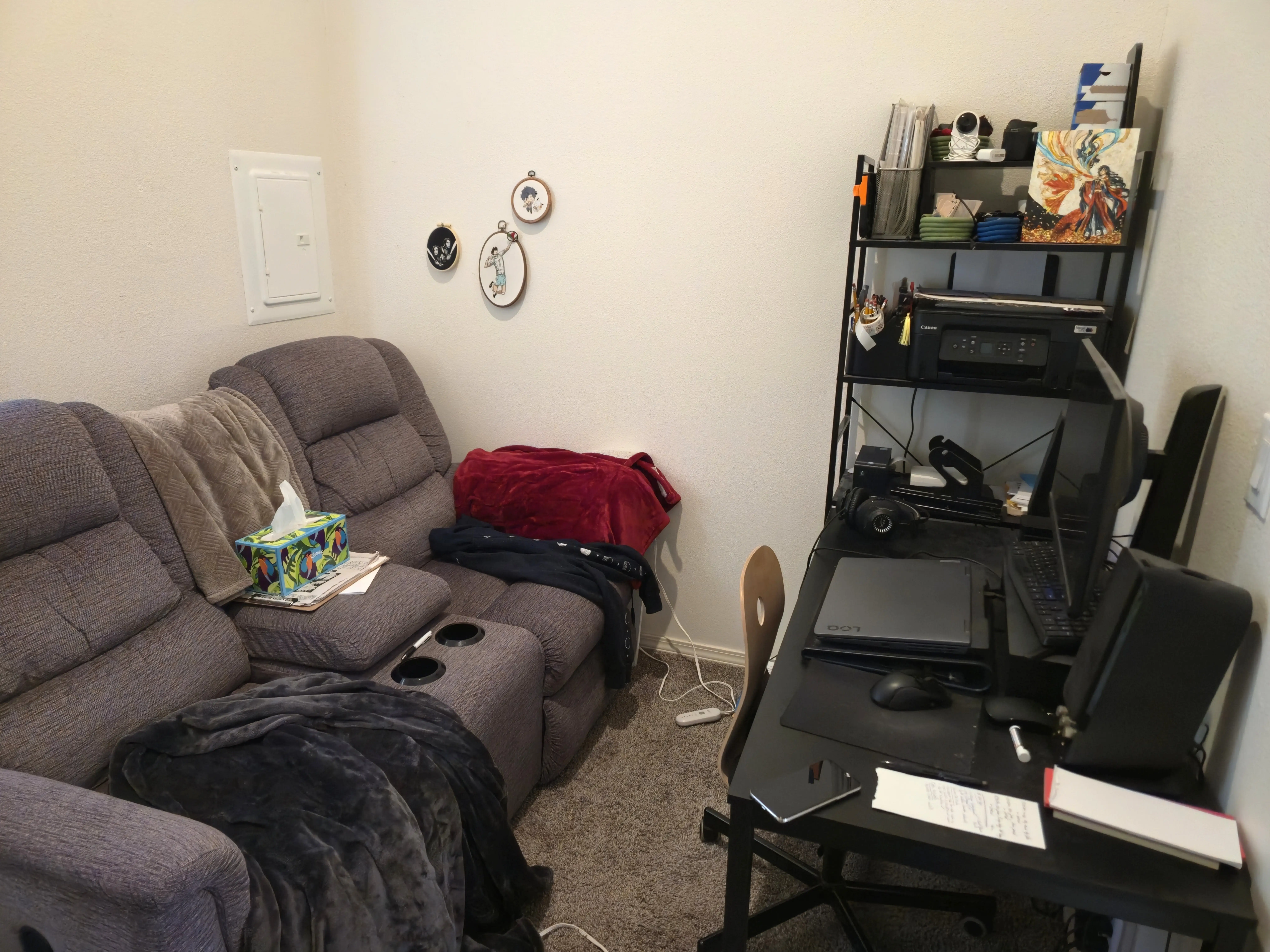 two-seat sofa with cu holder, desk, and shelving unit in room