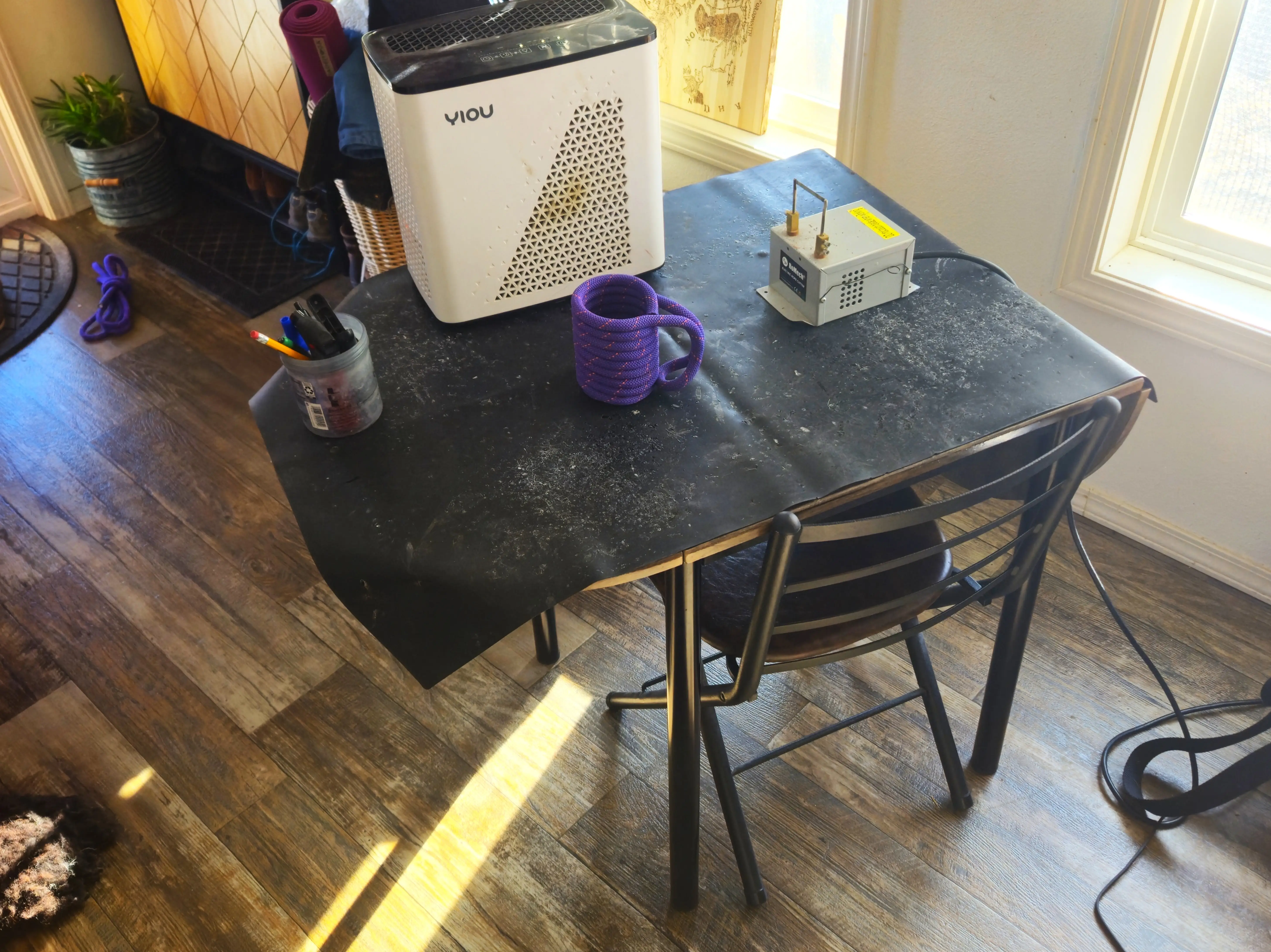 small table with chair covered with black piece of material and crafting supplies