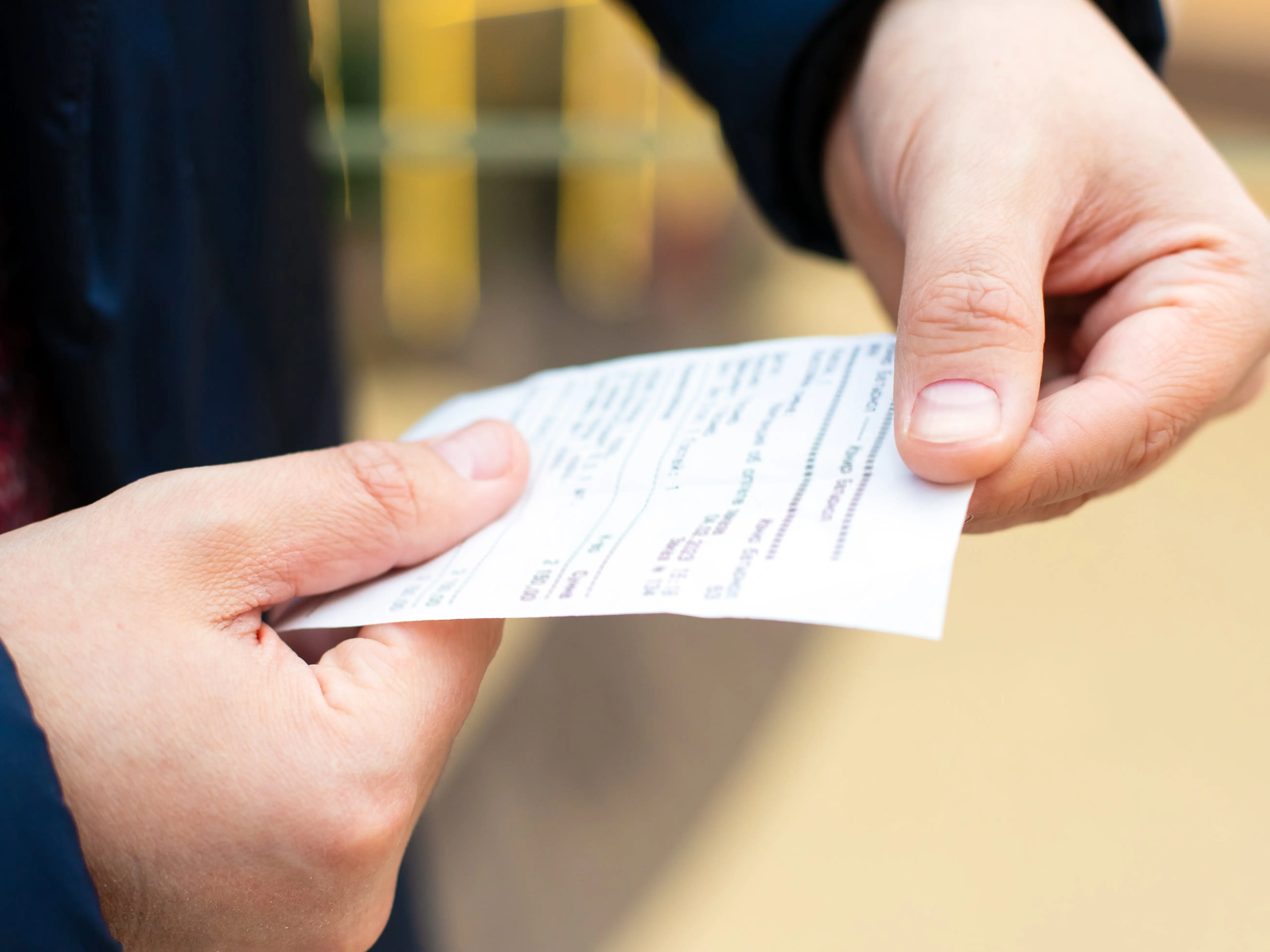 Hands holding a receipt.