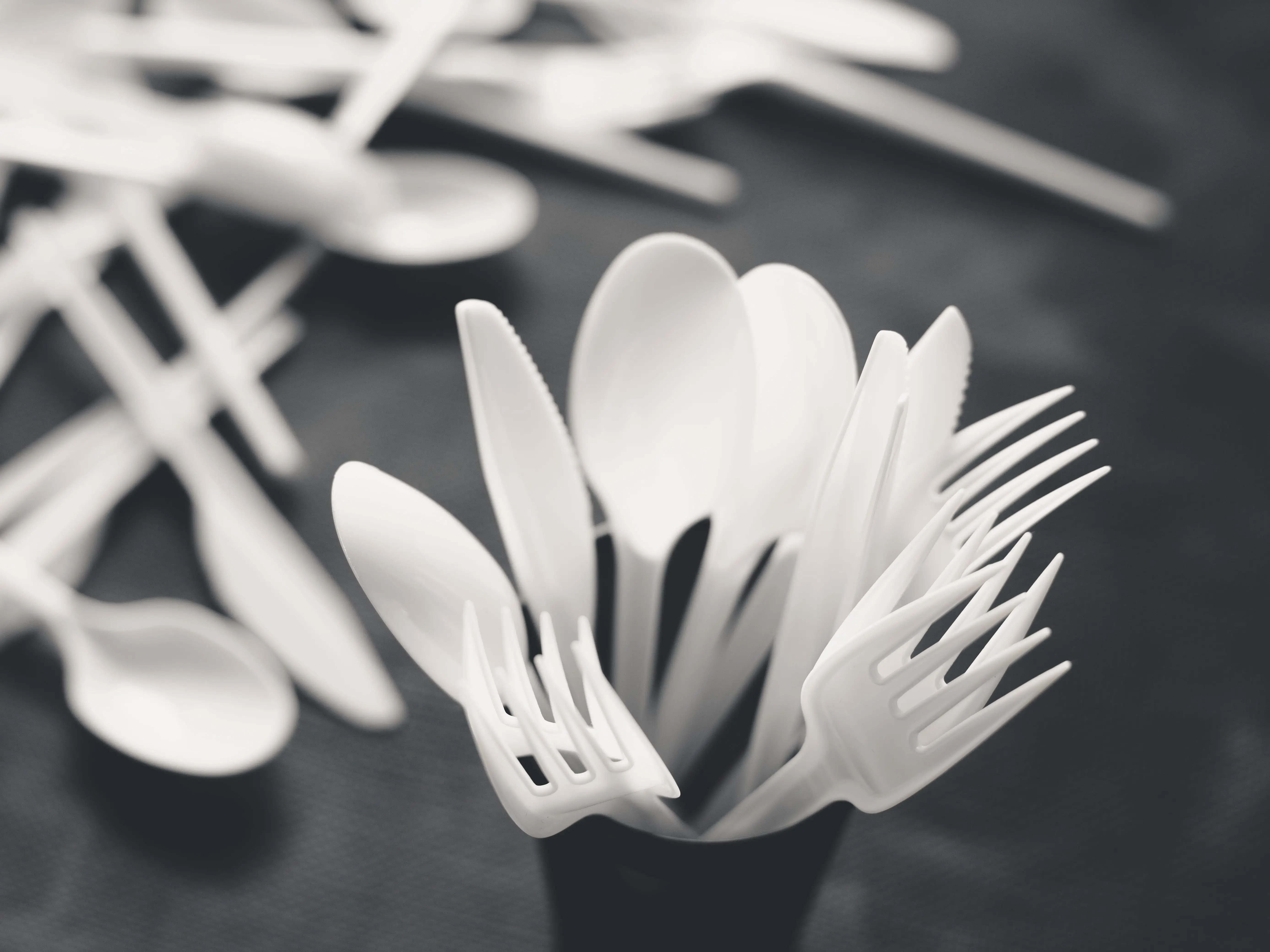 A cup of plastic utensils.