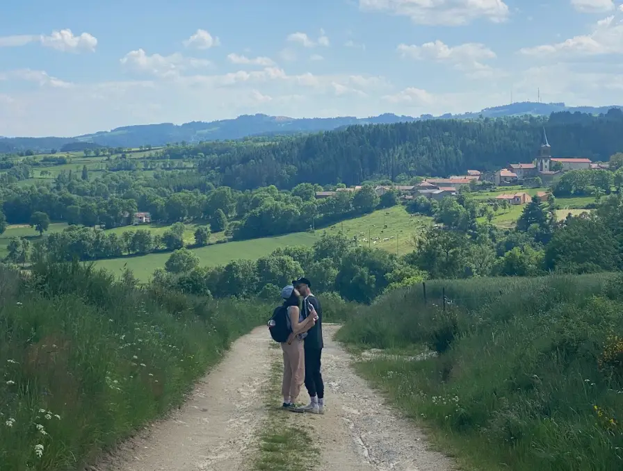 The writer and her husband kissing on a pathway, with a green landscape in the background.