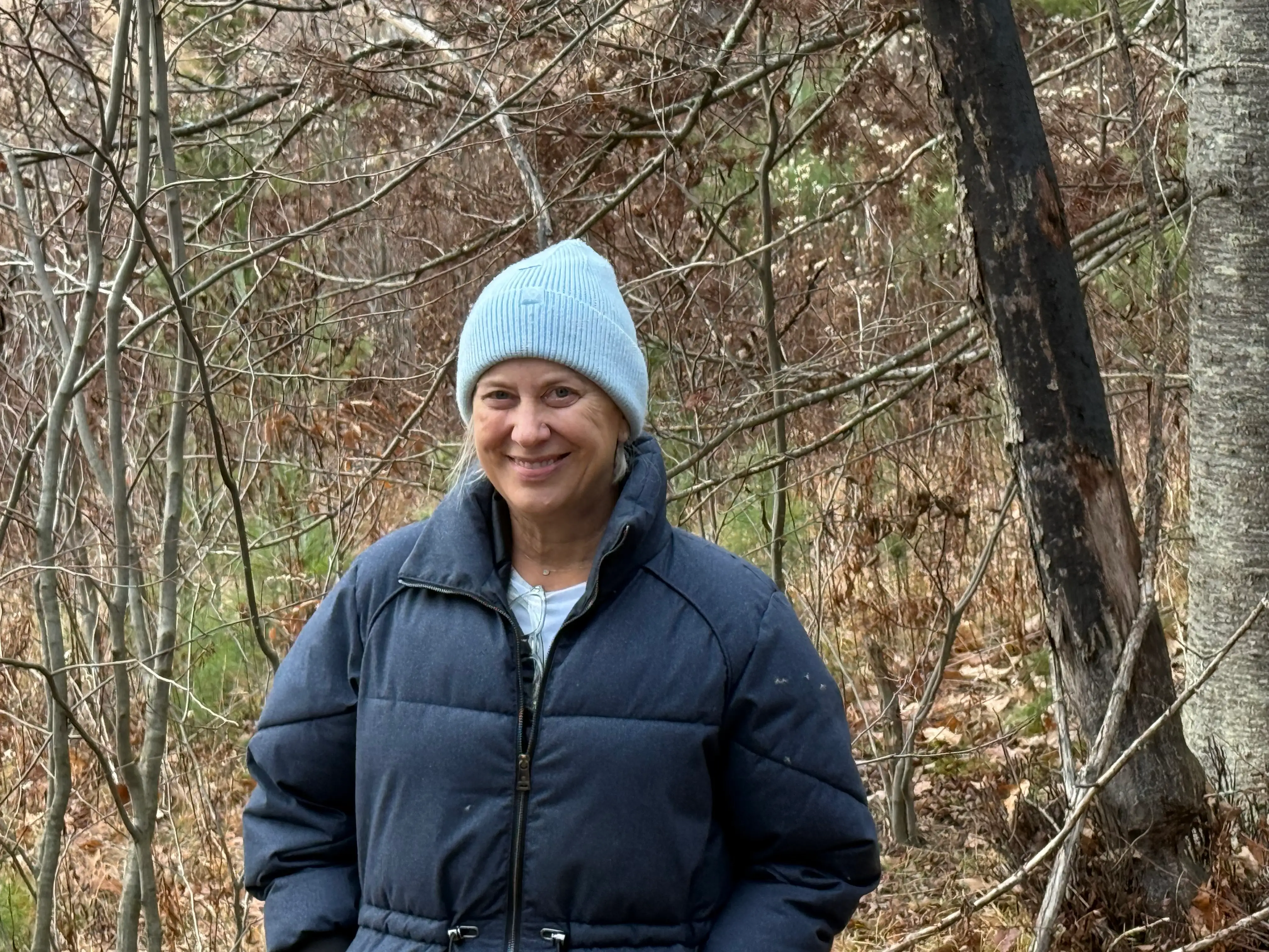 Author Sandra Gordon smiling in front of trees
