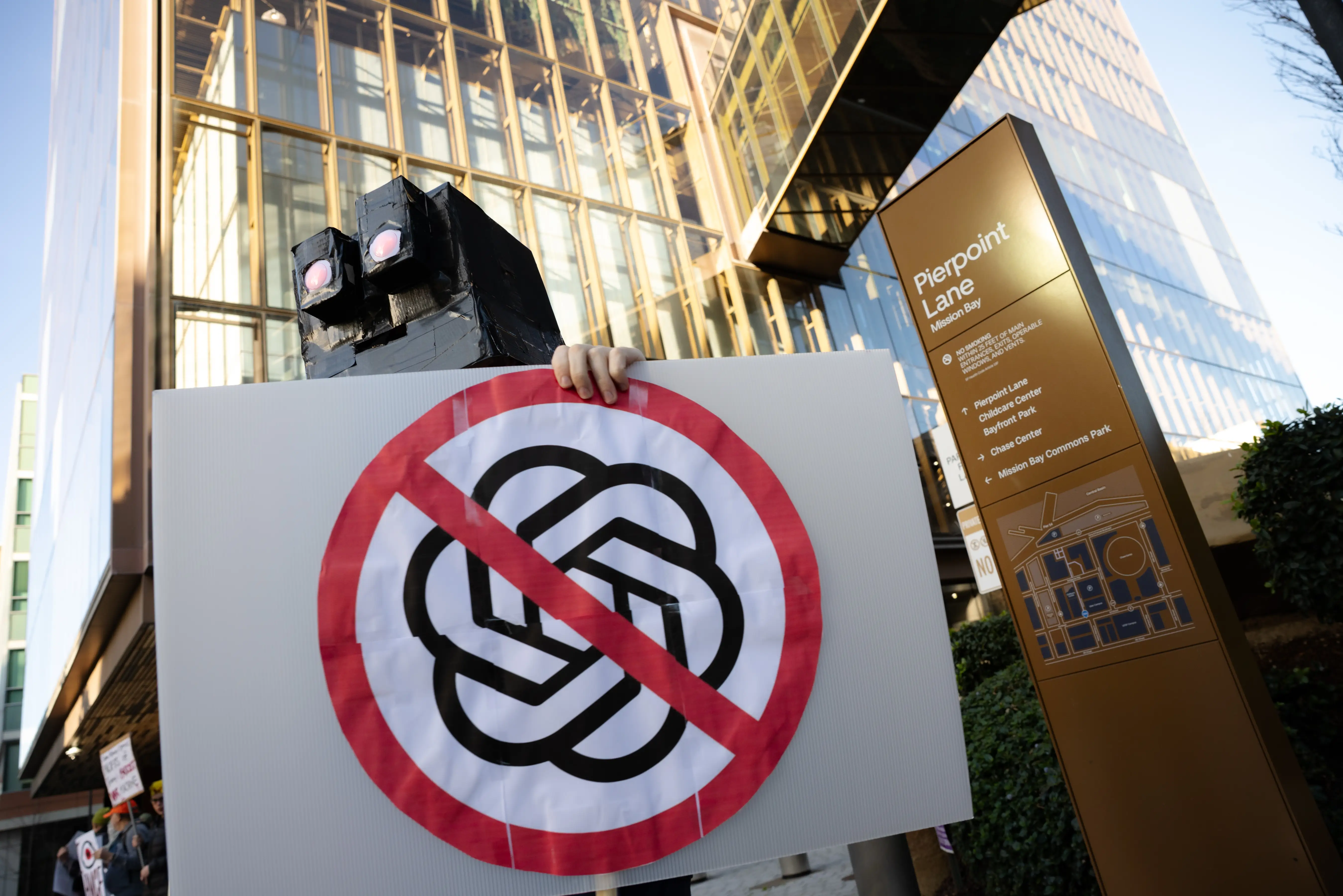A protester from the QuitGPT.org collective holds a sign against Open AI outside of their headquarters in San Francisco.
