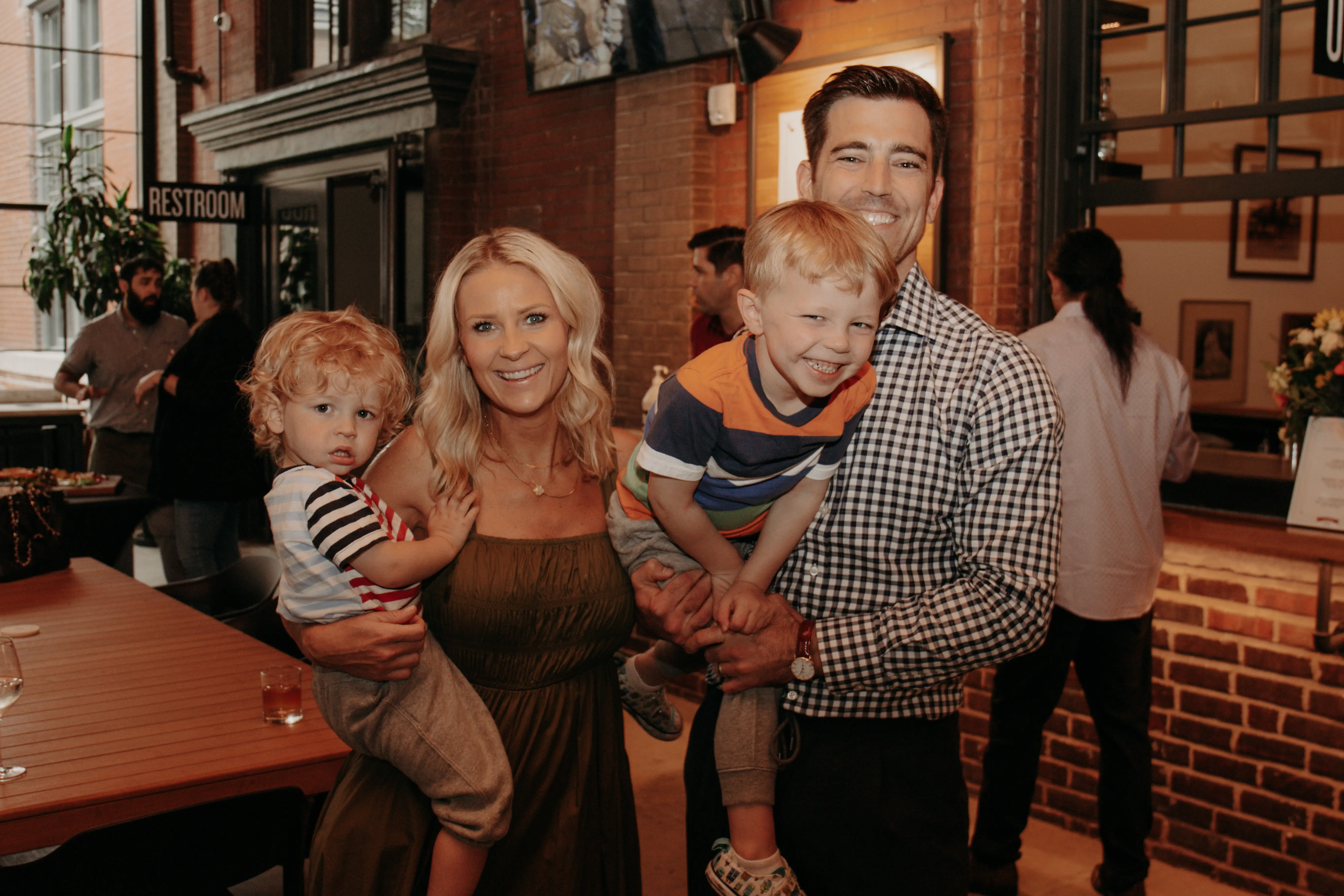 Young couple holding two young kids.