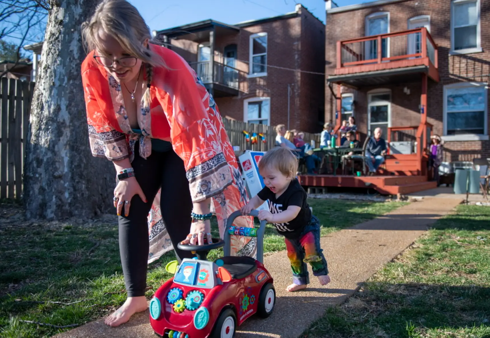 The writer and their child playing with a truck in their new backyard.