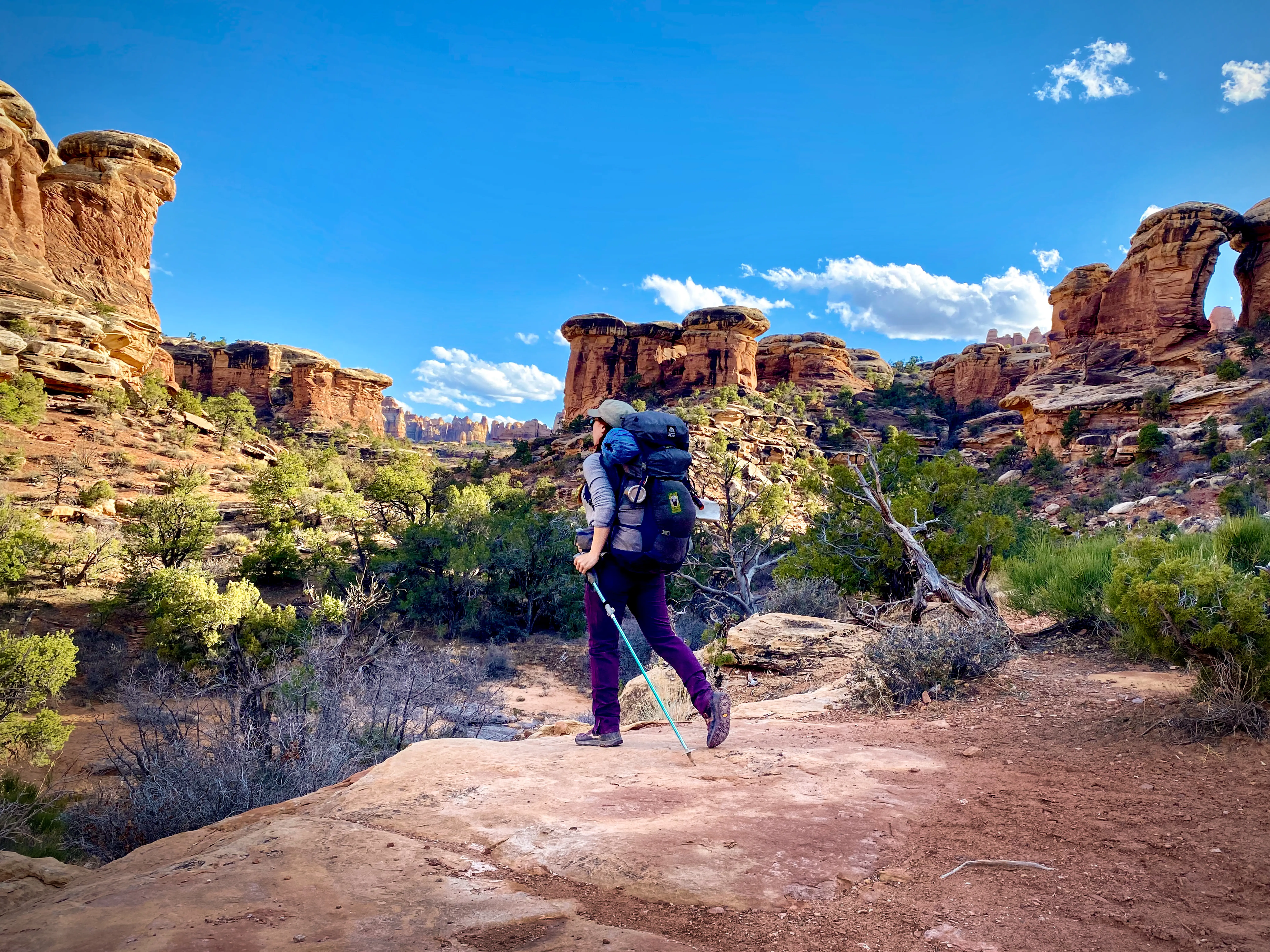 Woman in backpack walking through Canyonlands national park
