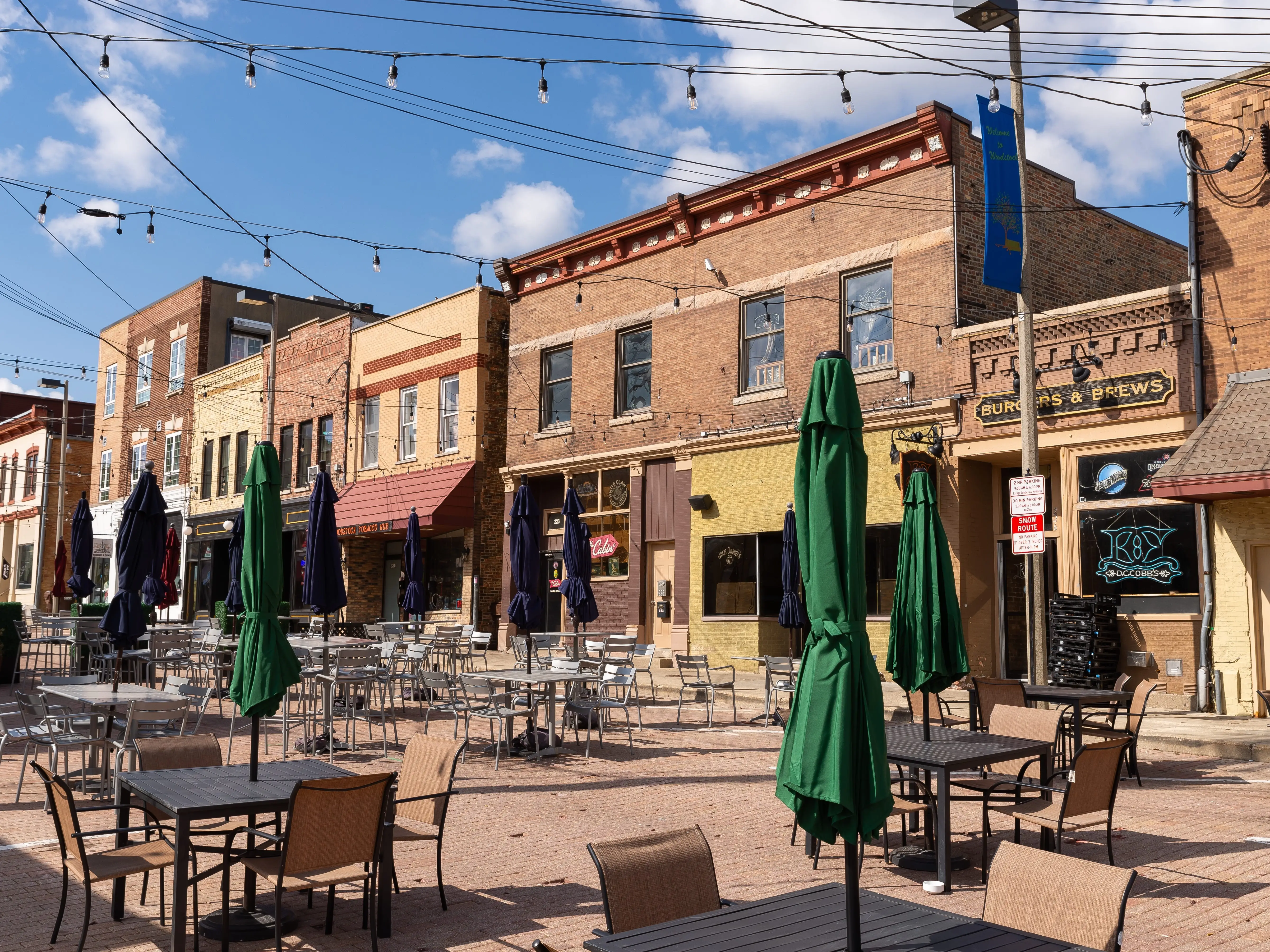 Dining tables in front of buildings.