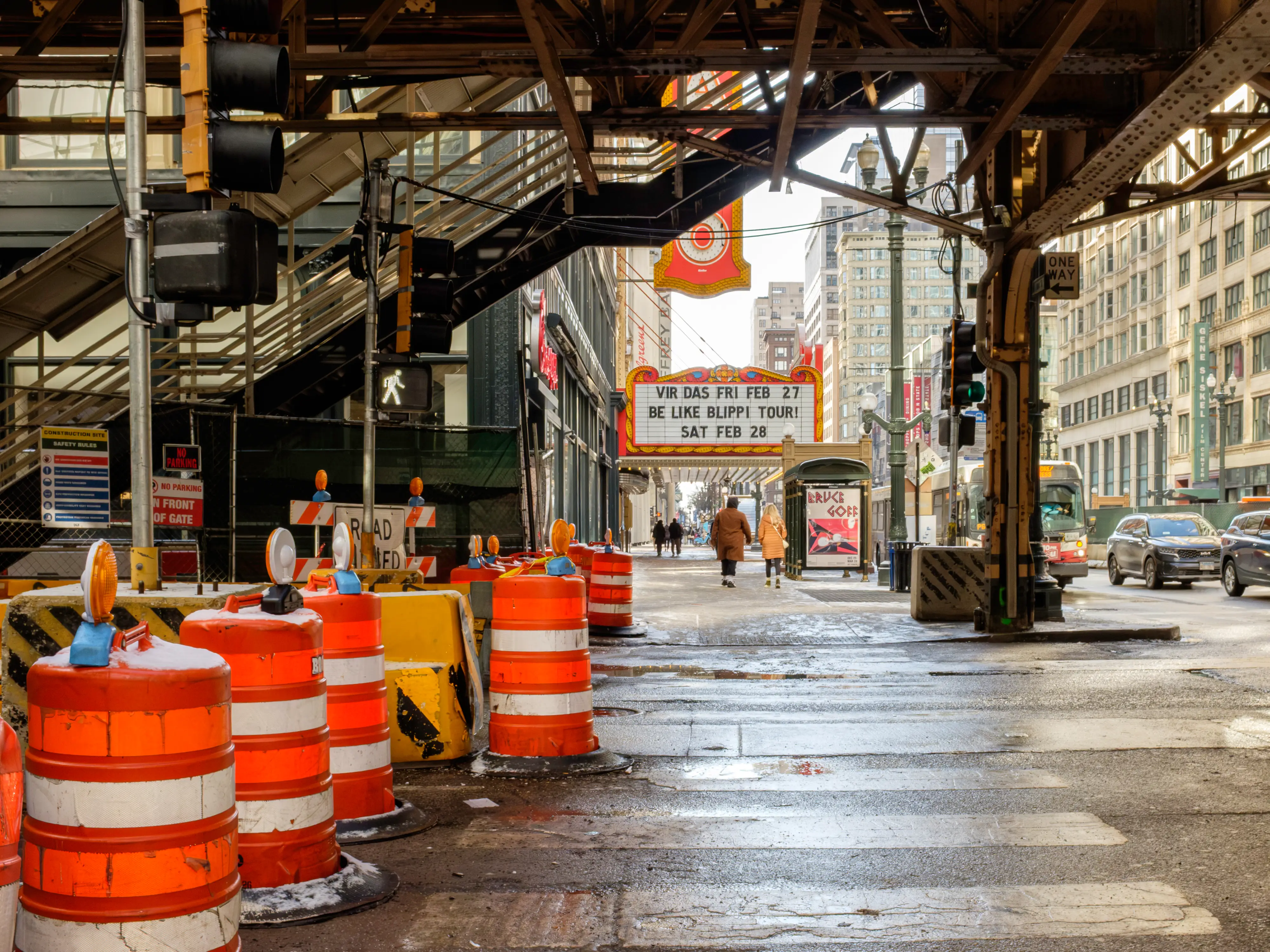 A cross walk with construction on the left beneath a bridge in Chicago