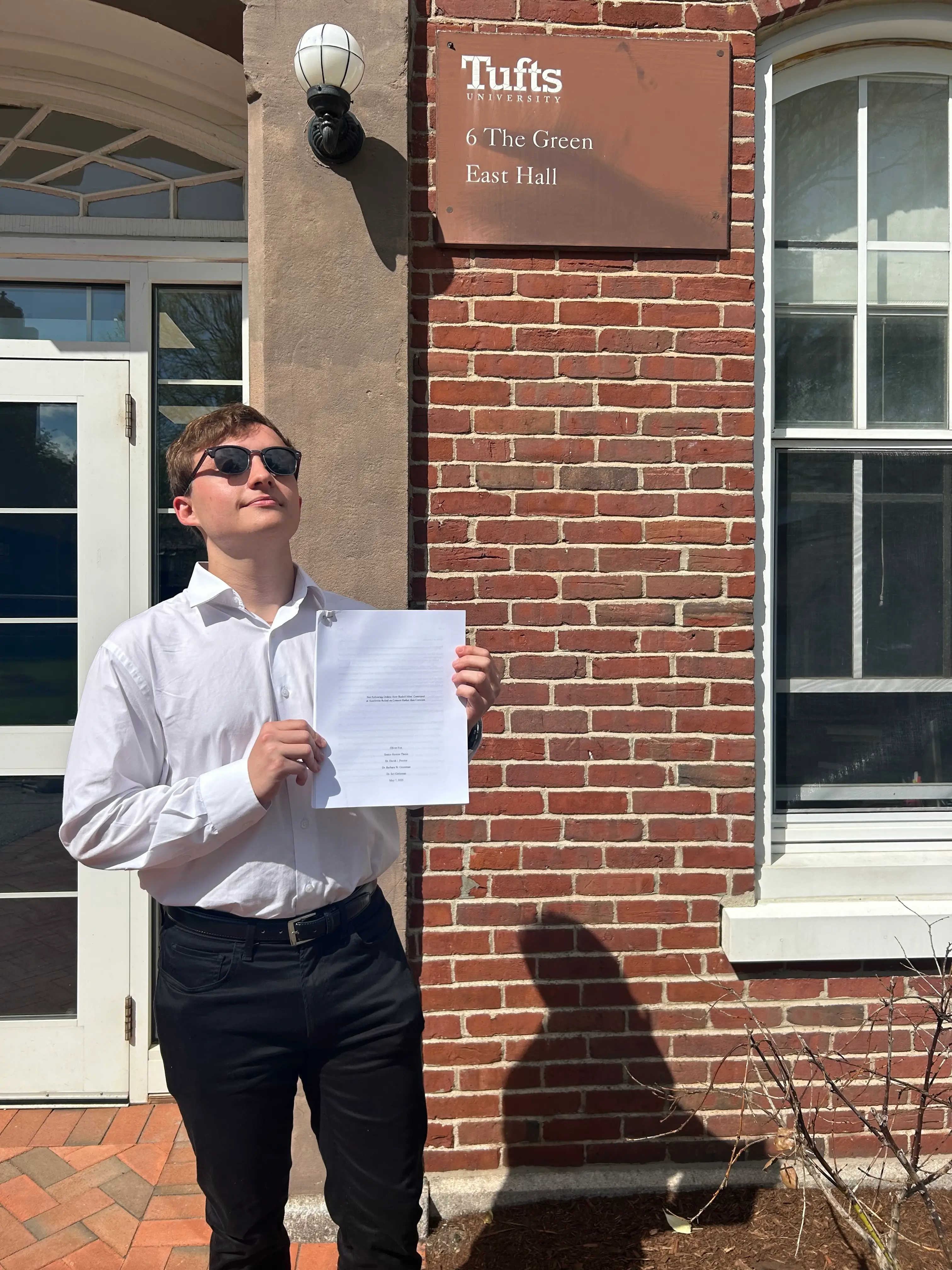 Oliver Fox holding up his senior thesis