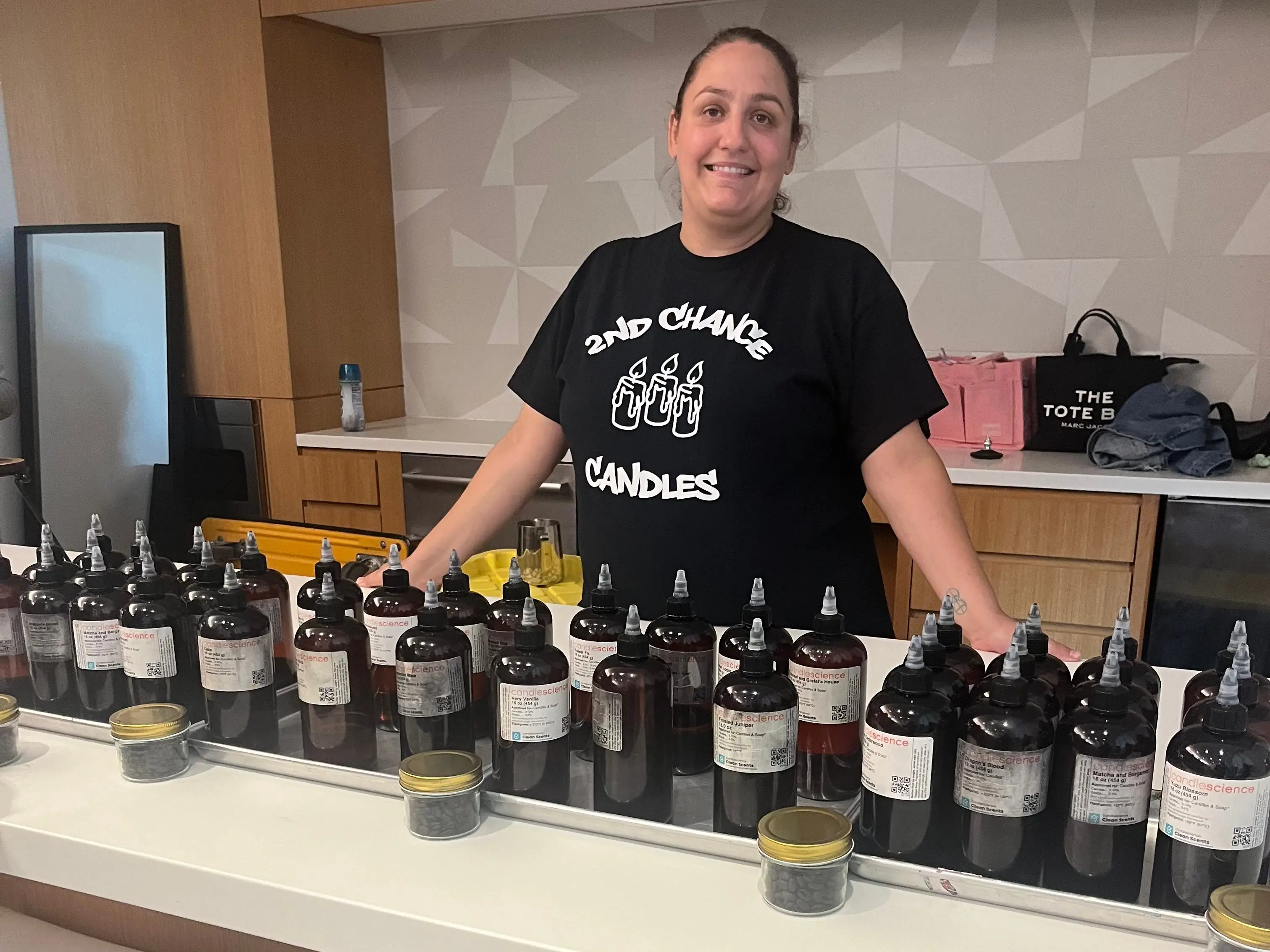A woman with rows of bottles in front of her.