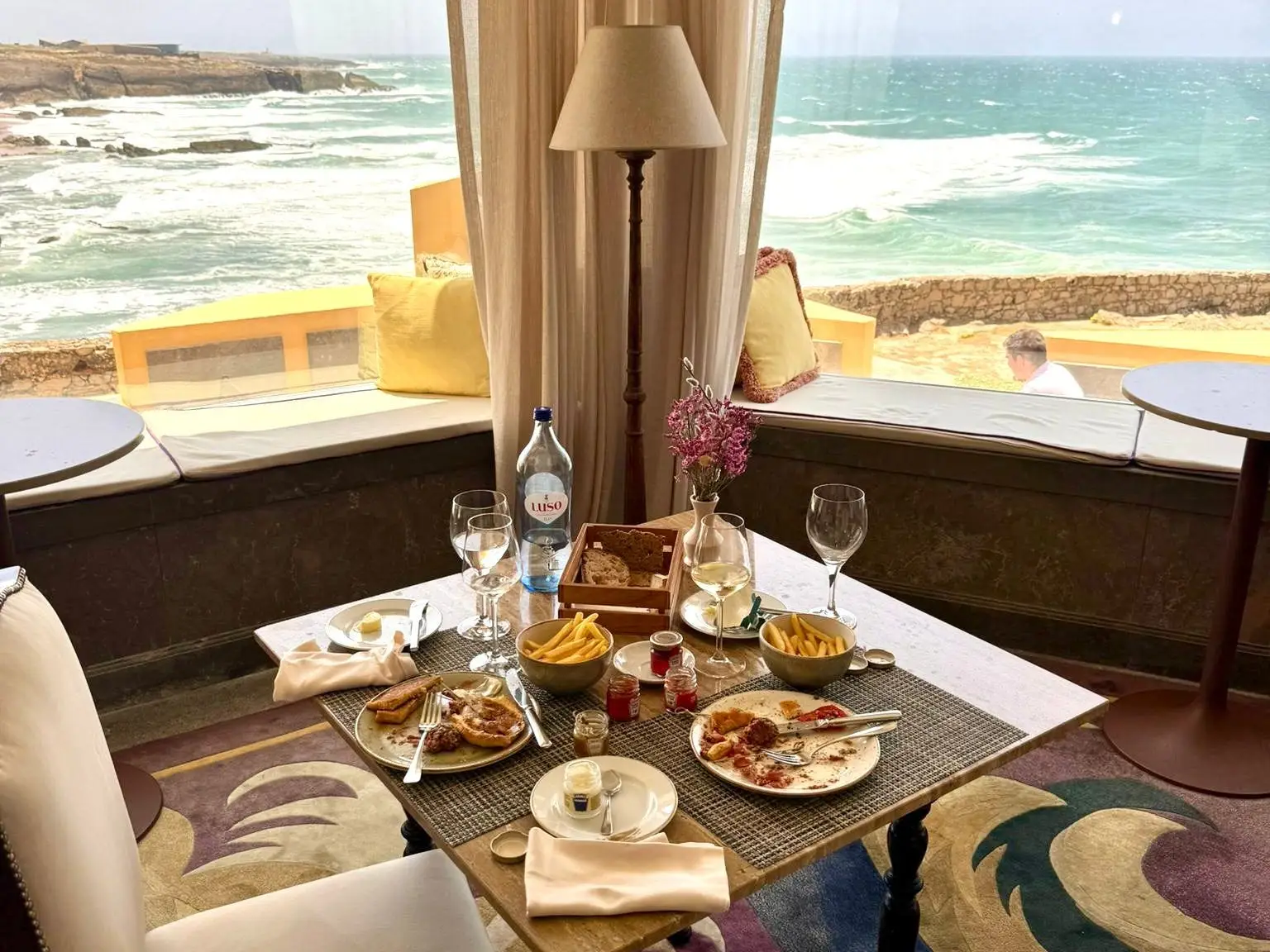 Table set for dinner with view of beach behind it