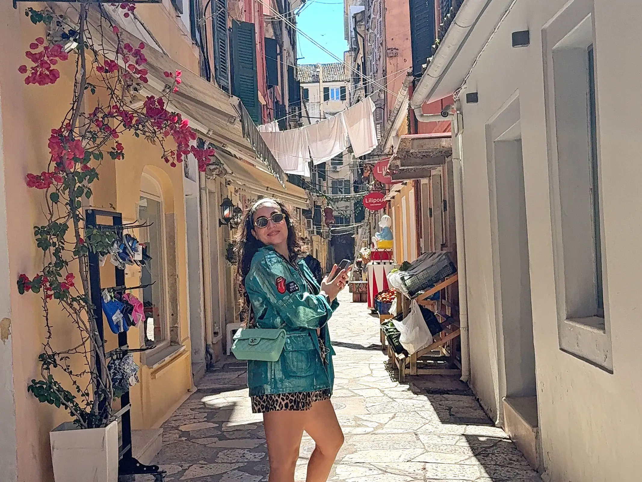Fani poses in a small alley lined with shops.