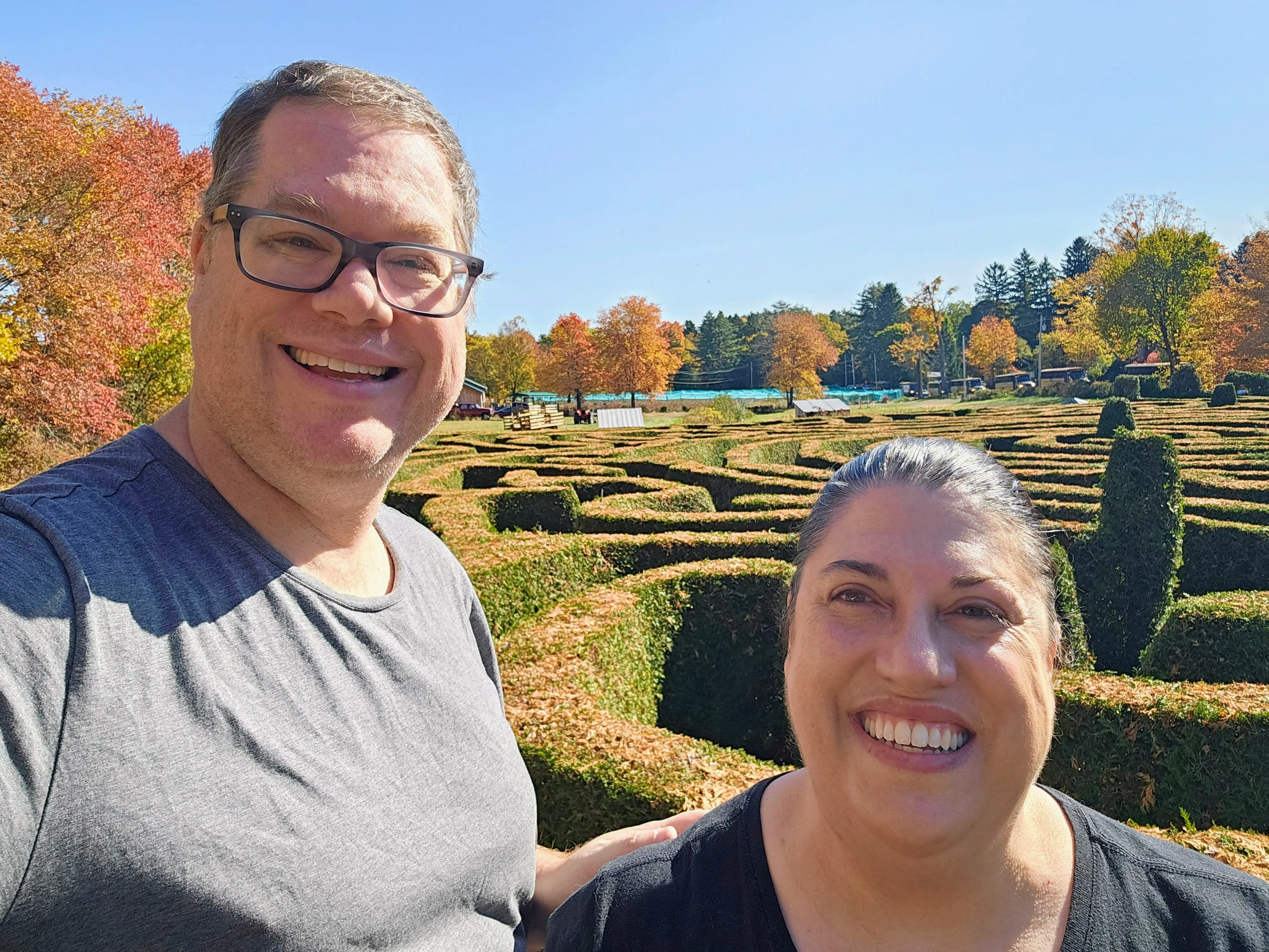 Julia and her husband stand in a hedge maze.