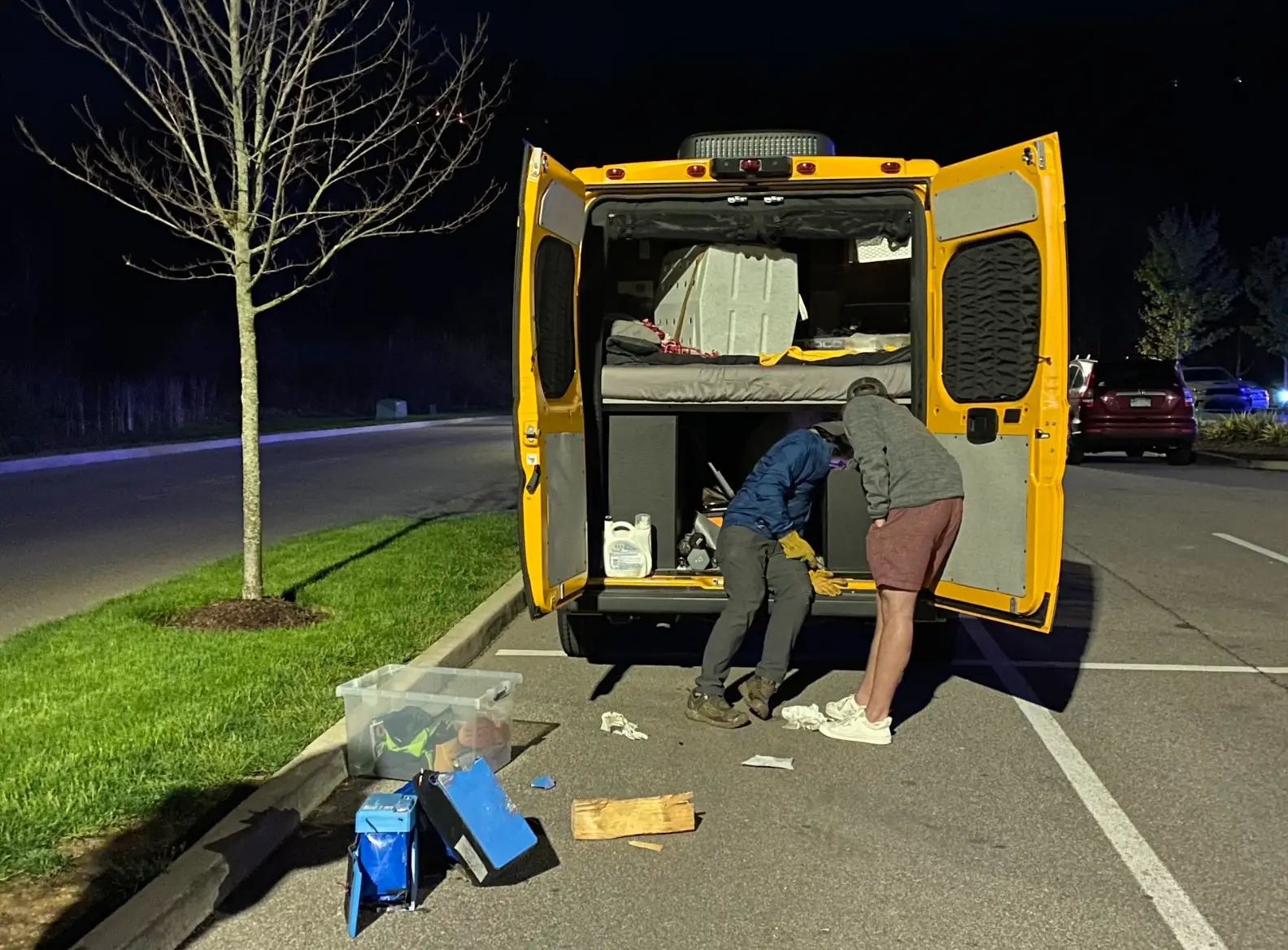 The writer's partner working on an electrical issue with their van at nighttime.