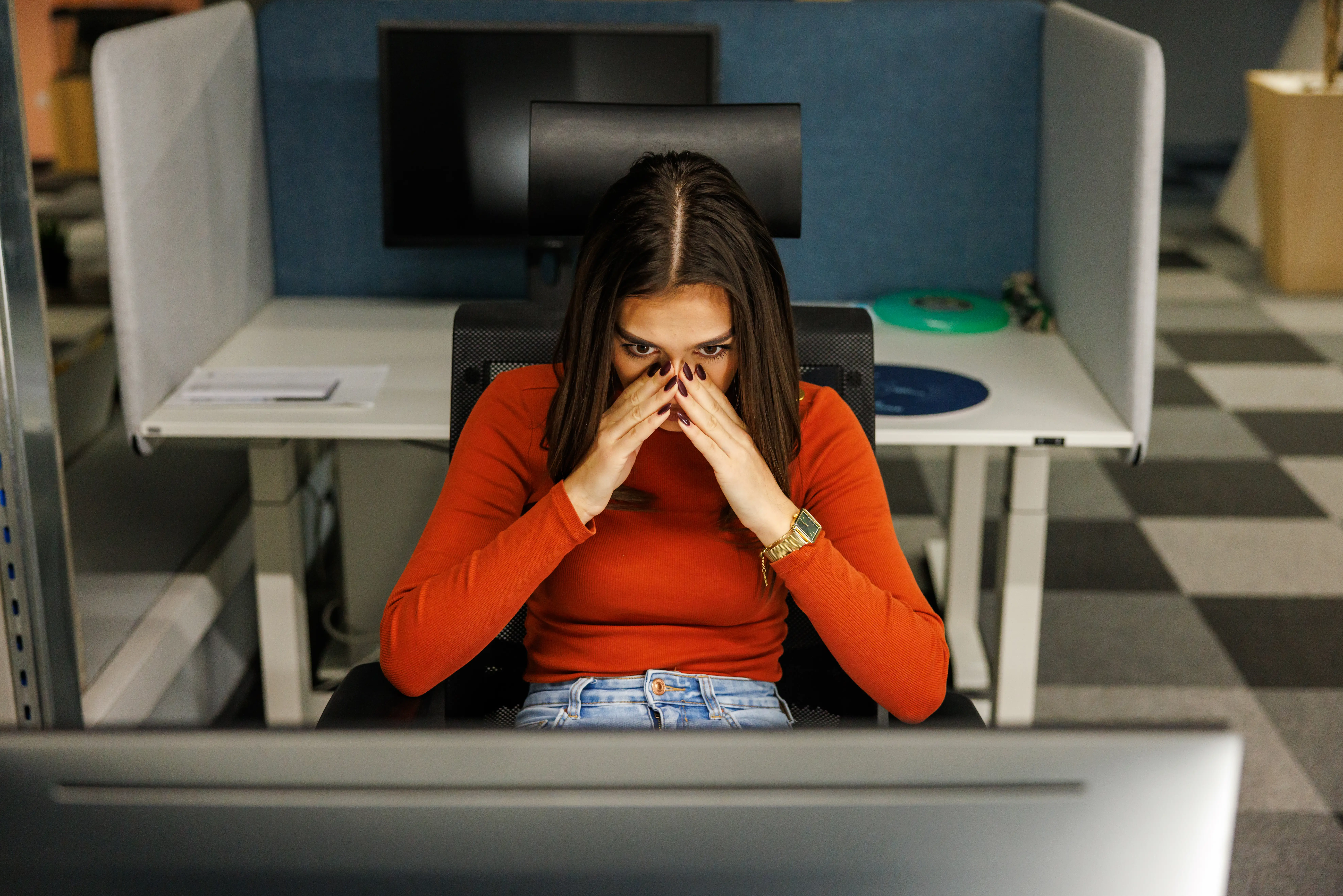 Woman sitting at a desk at work looking stressed