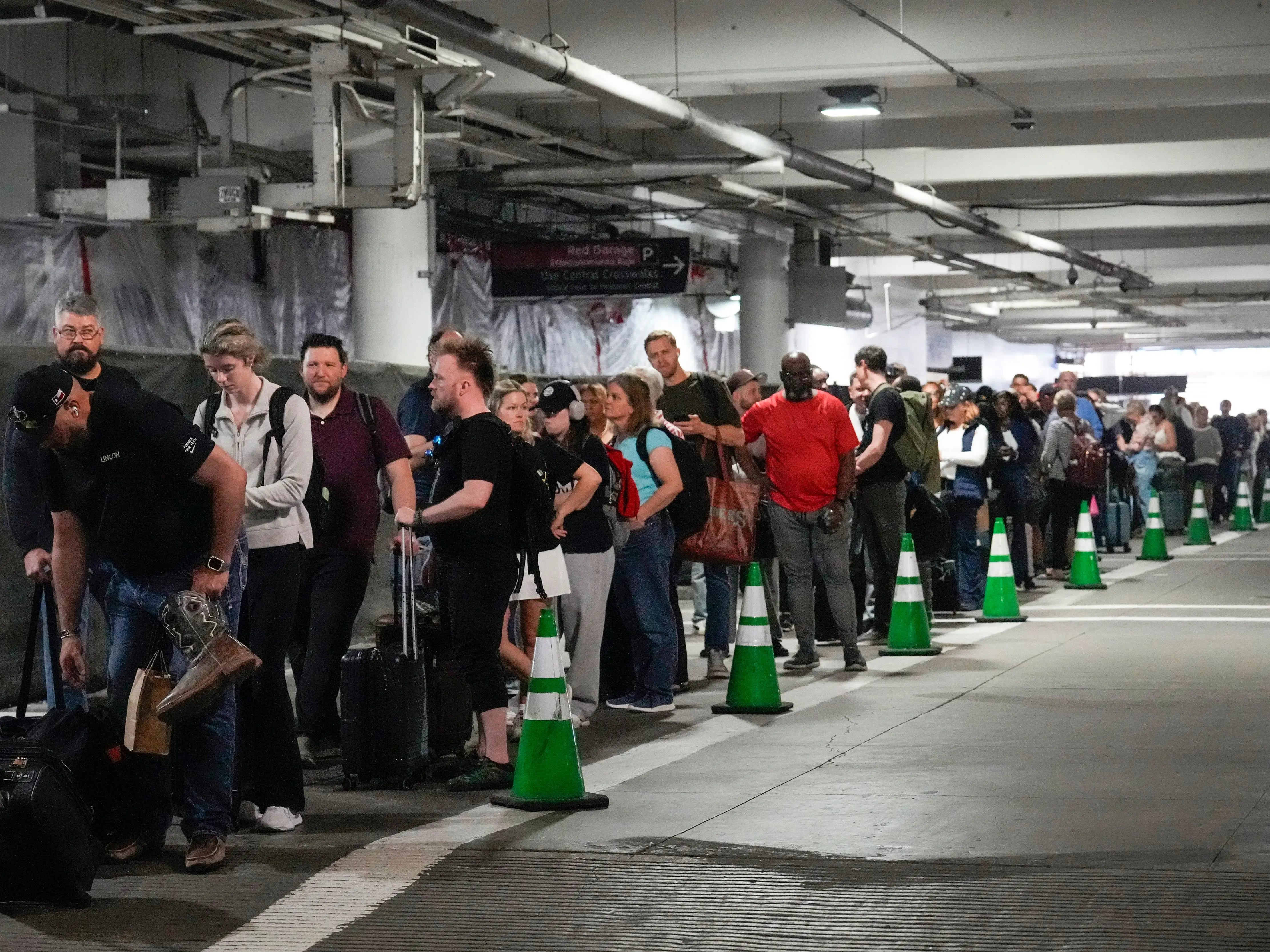 Passengers wait in a long line in a parking garage at William P. Hobby Airport in Houston.