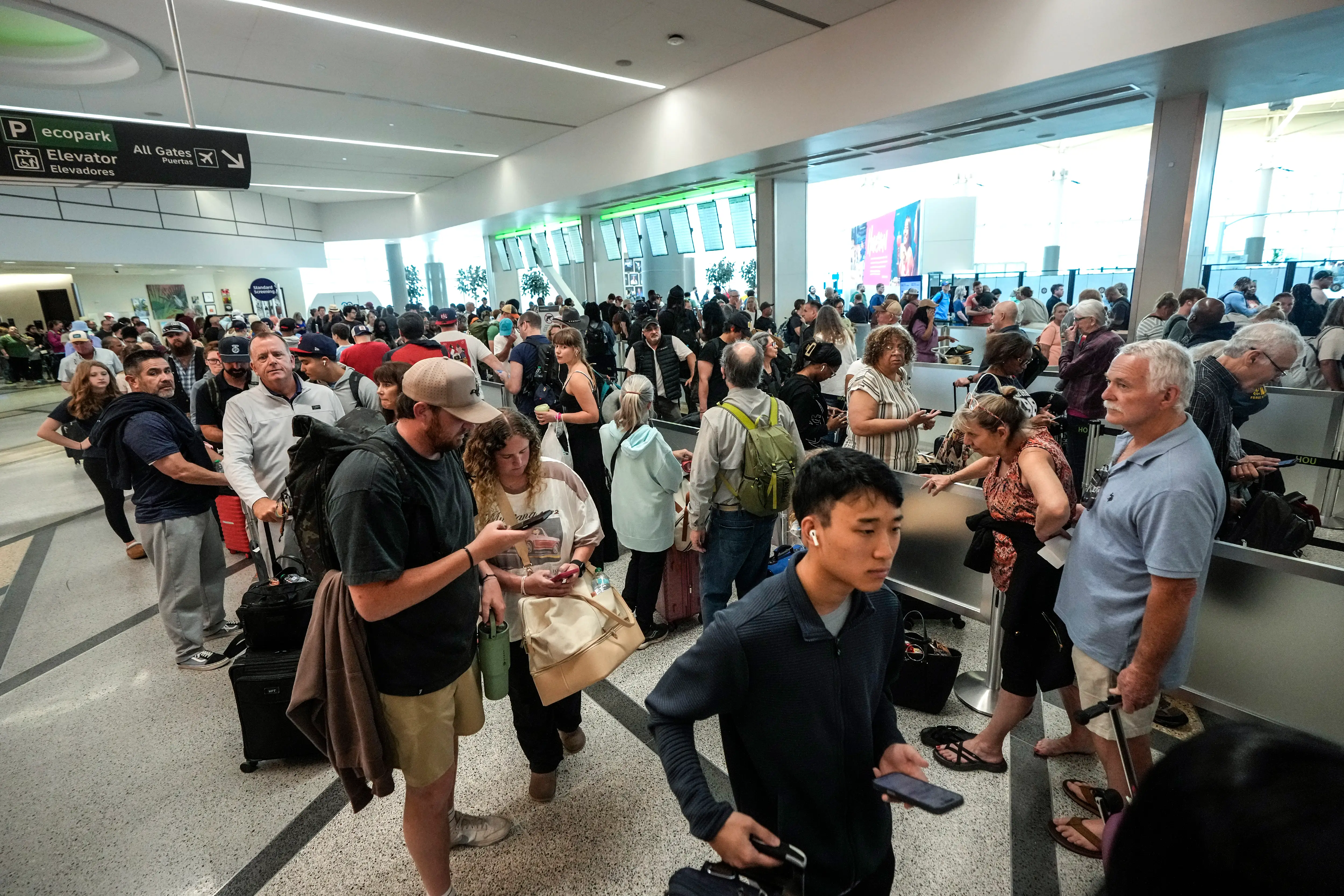 Airline passengers wait in long lines to get through the TSA security screening at William P. Hobby Airport in Houston, Sunday, March 8, 2026