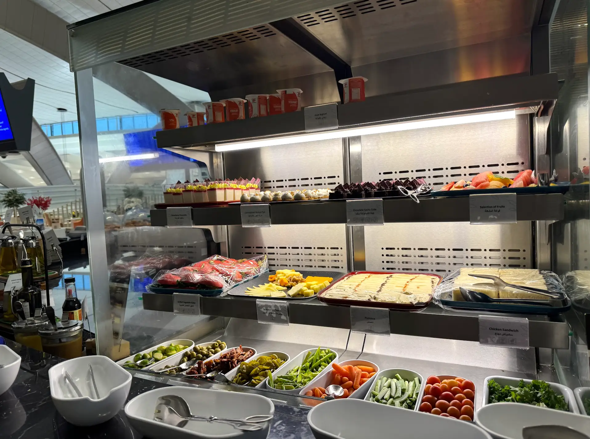 free food including veggies and cheeses inside an airport lounge