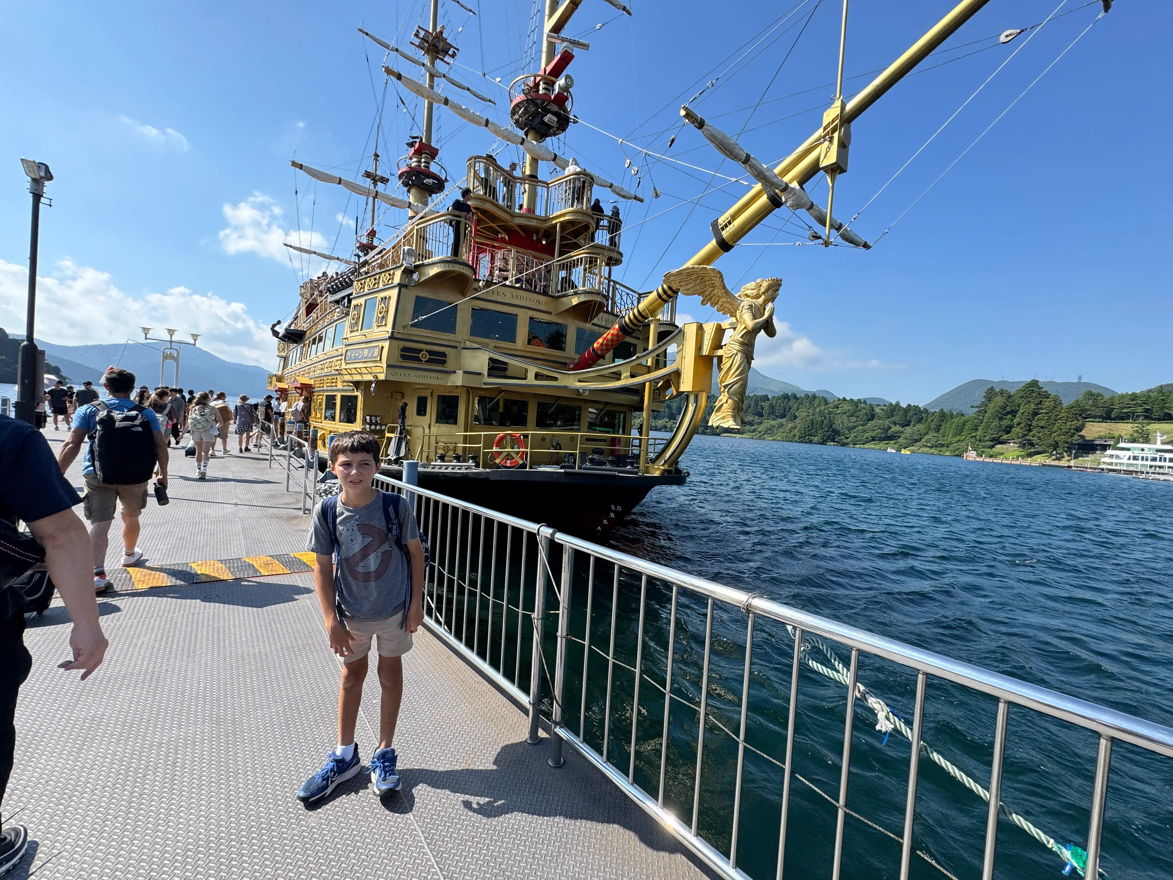 Child standing next to boat in water