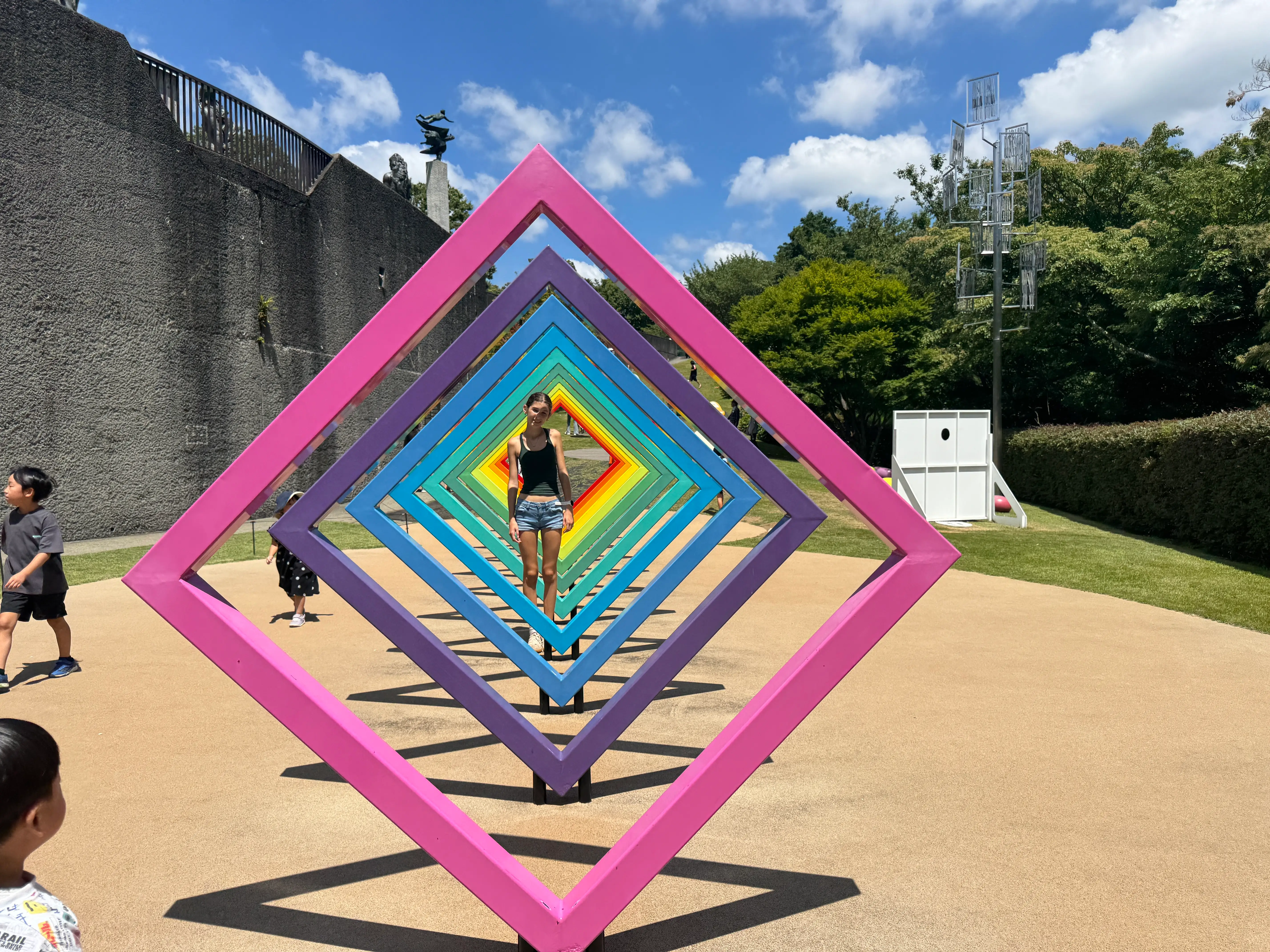 Child standing in diamond rainbow sculpture
