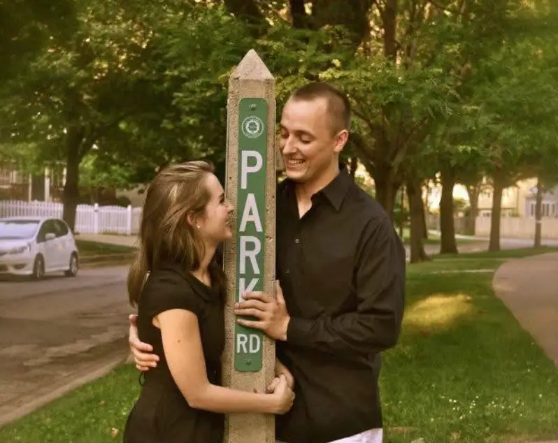 The writer and her husband standing in a park, looking into each other's eyes.