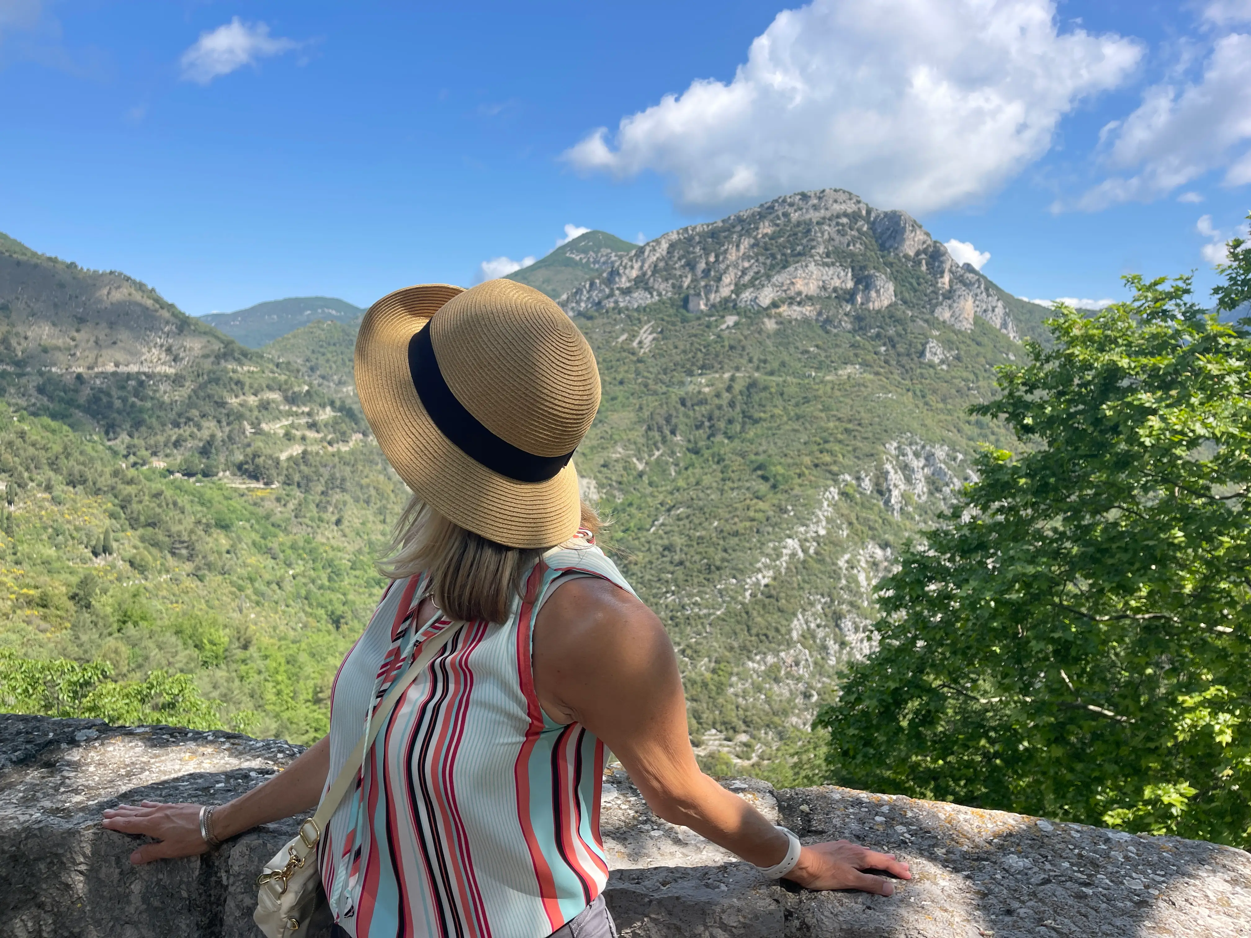 Woman turning away from camera with view of France behind her