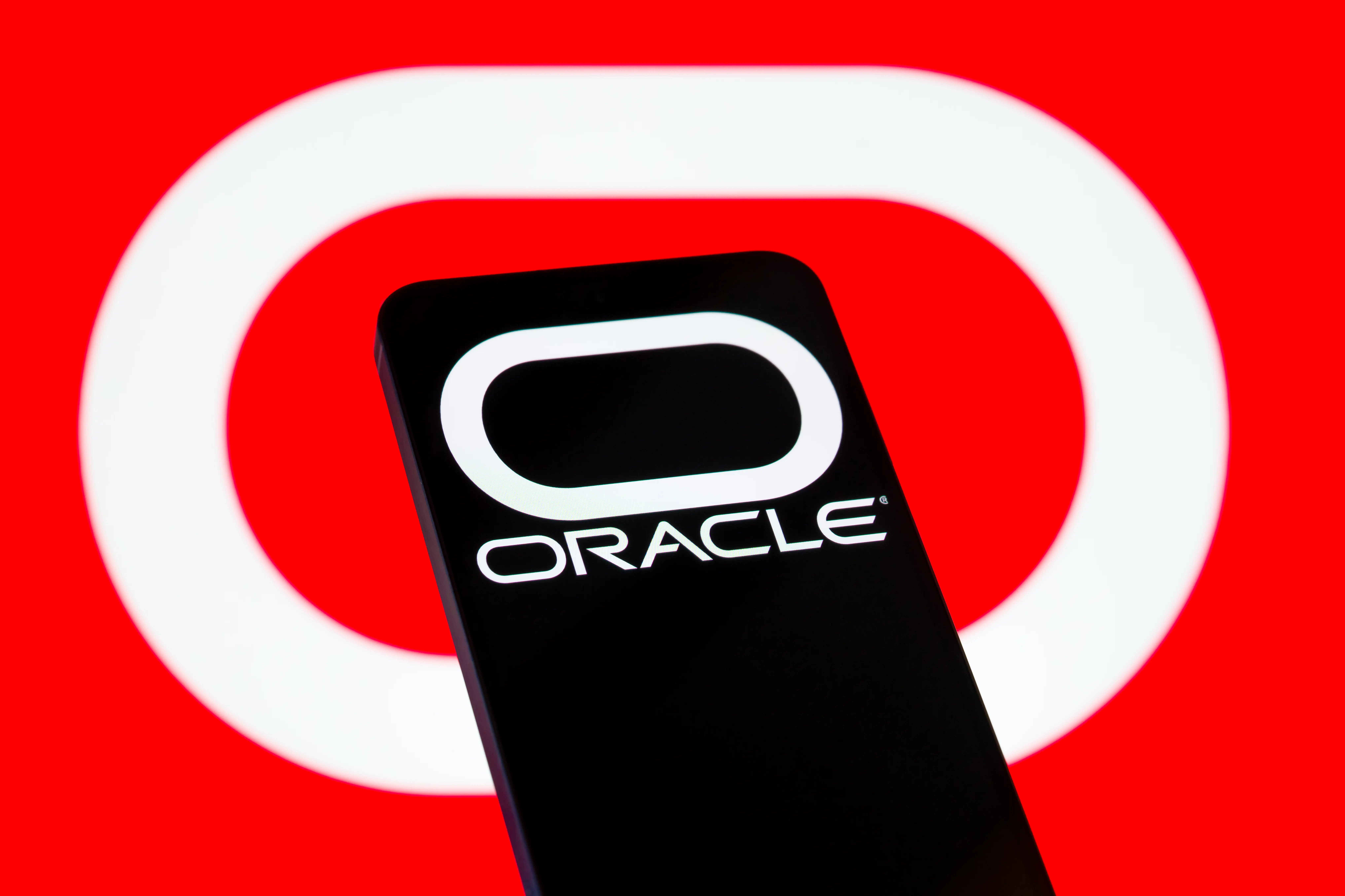 Oracle logo on a phone in front of a red background