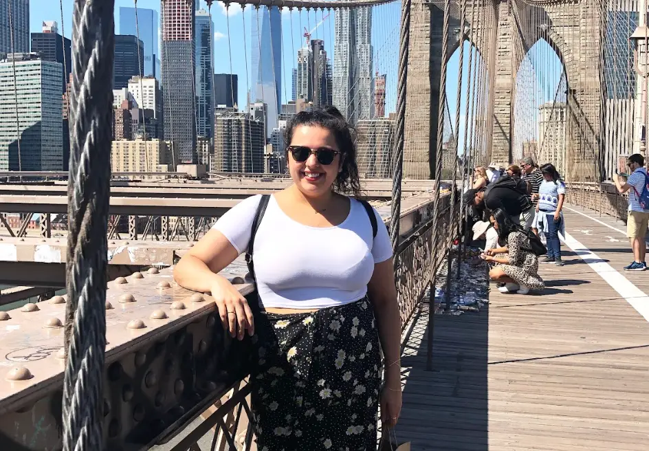 The writer standing on the Brooklyn Bridge on a solo trip.