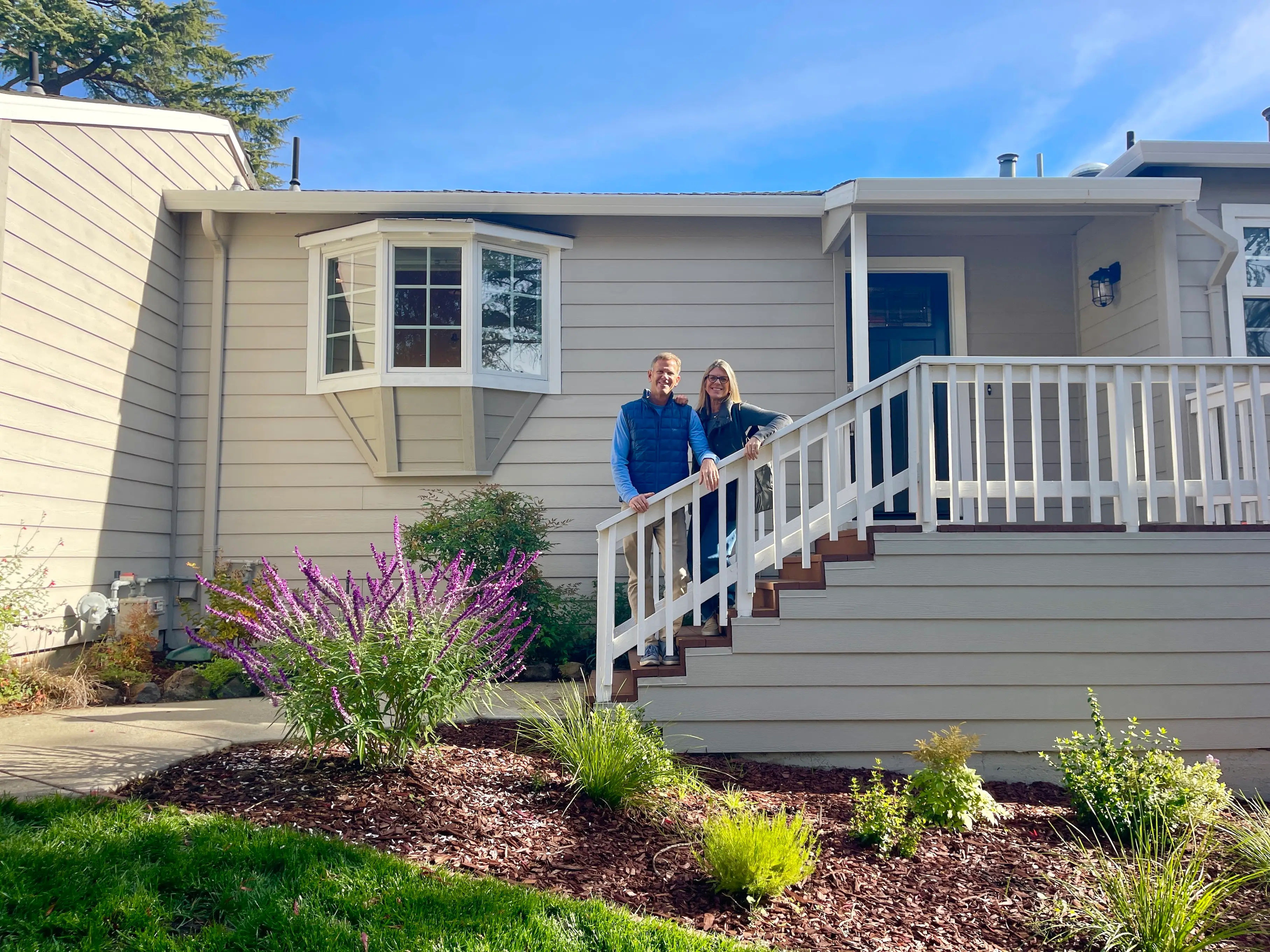 Couple smiling in front of house