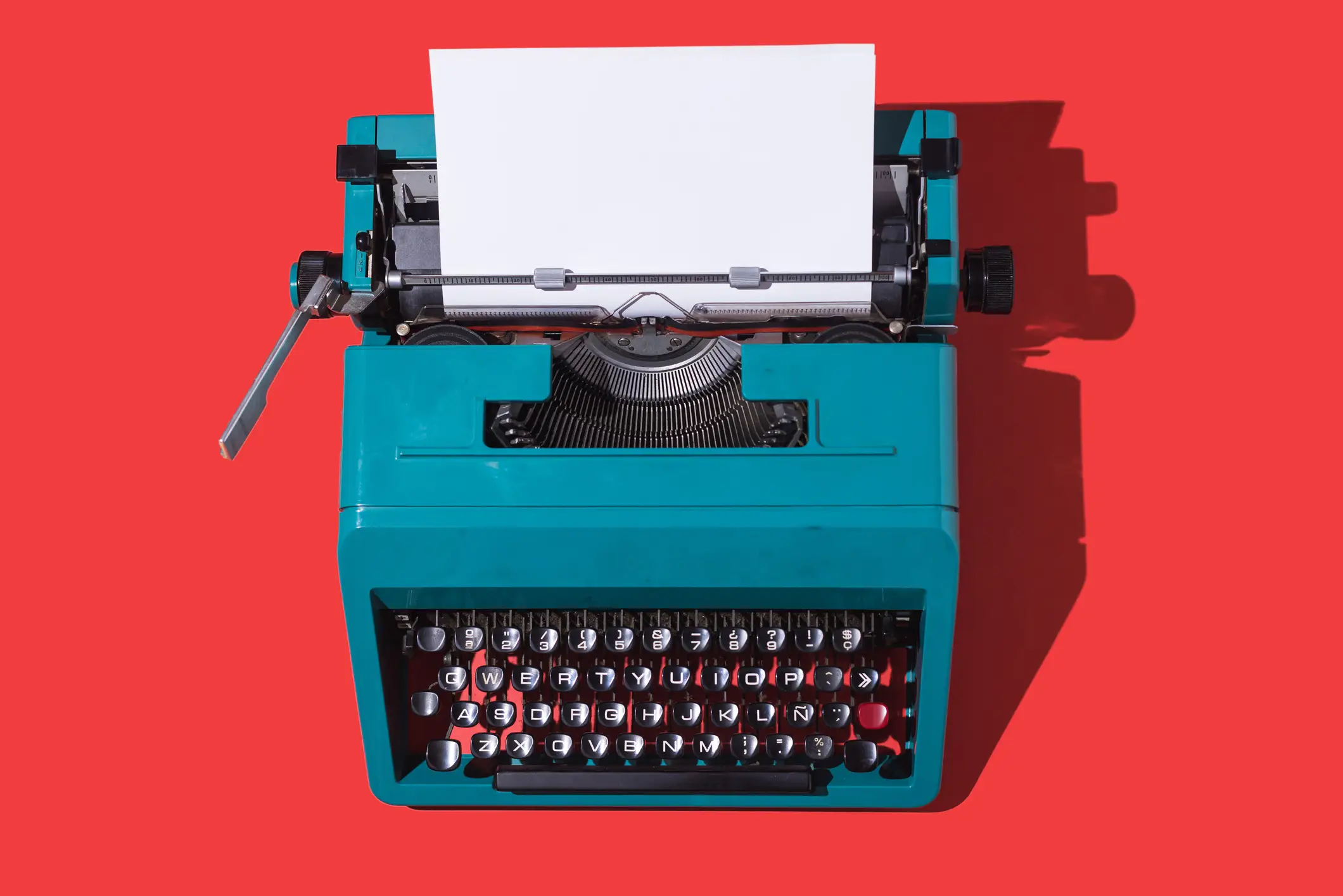 a typewriter against a red background