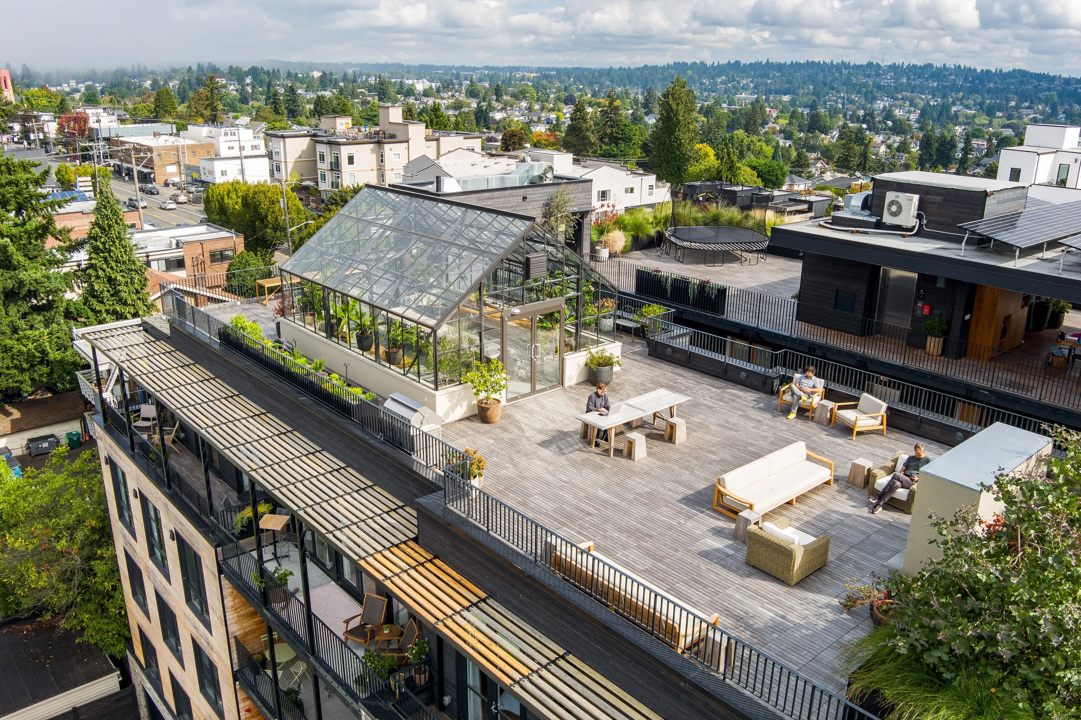 A rooftop of a residential building with people sitting on furniture.
