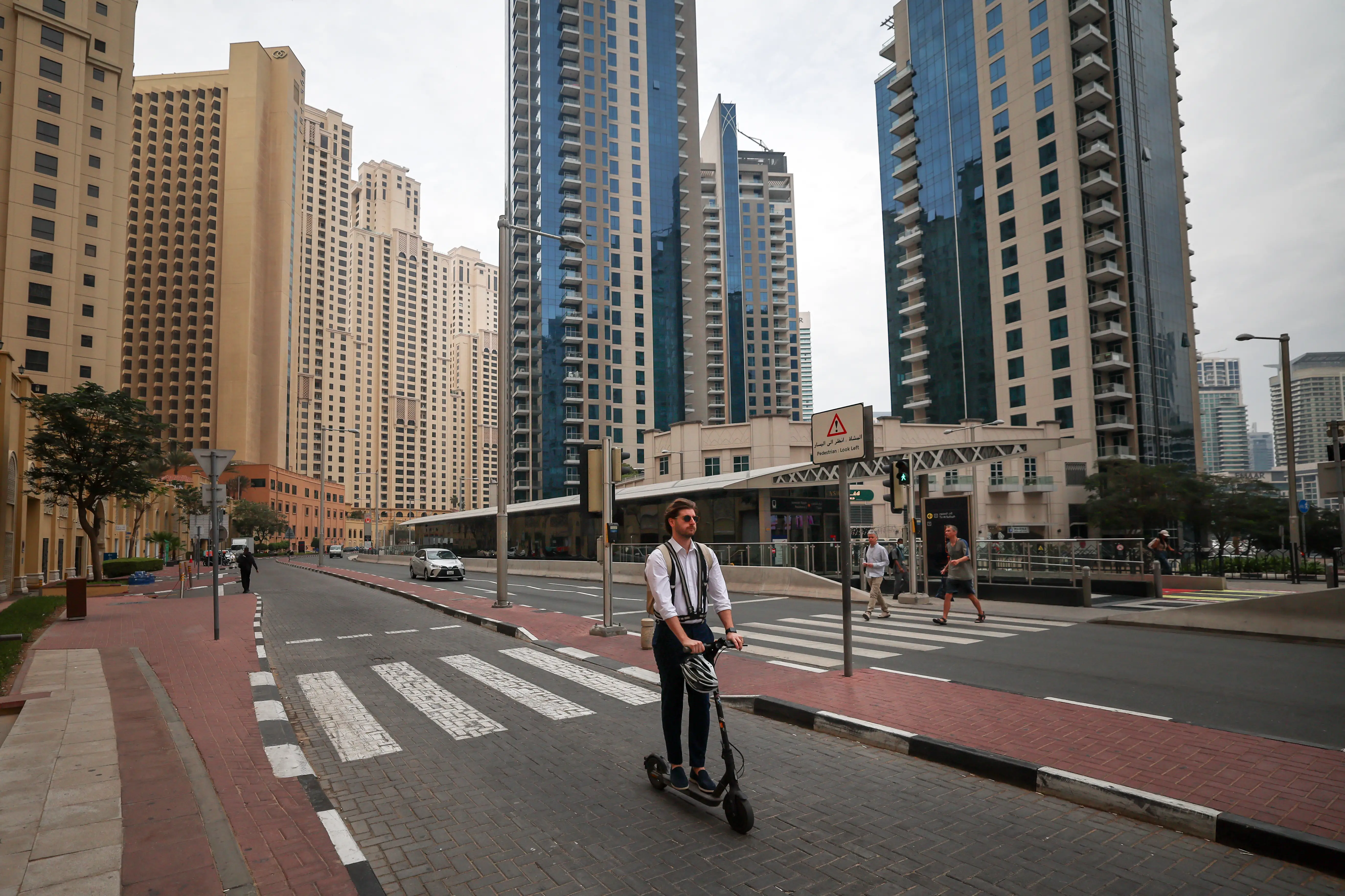 A man rides a scooter along a street in Dubai's Jumeirah Beach Residence (JBR) on March 10, 2026. The Gulf countries have long been seen as islands of stability in the Middle East, but the war in the region could threaten their prosperity, analysts said, pointing to risks to their revenues and reputations as business havens. (Photo by FADEL SENNA / AFP via Getty Images)