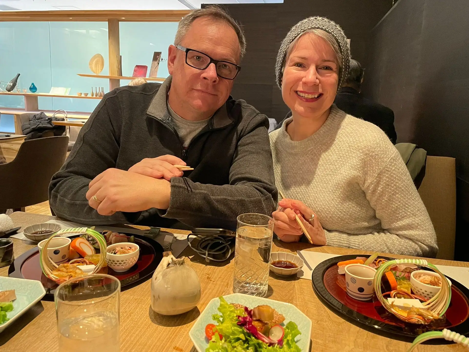 Erika Ebsworth-Goold and her husband sitting in a Japanese restuarnat with food in front of them on the table