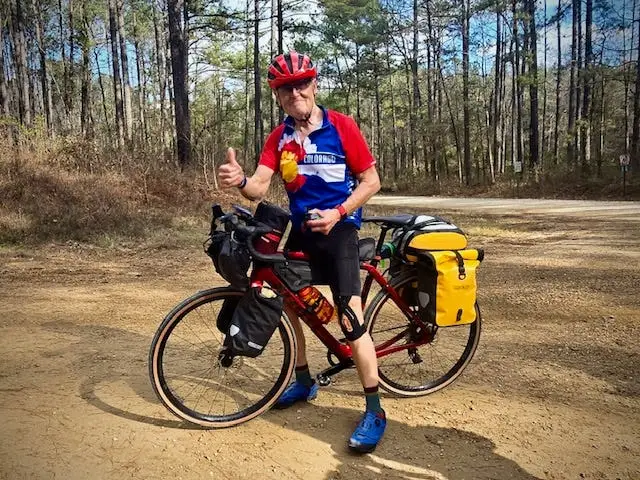 A man on a bicycle giving the thumbs-up sign.