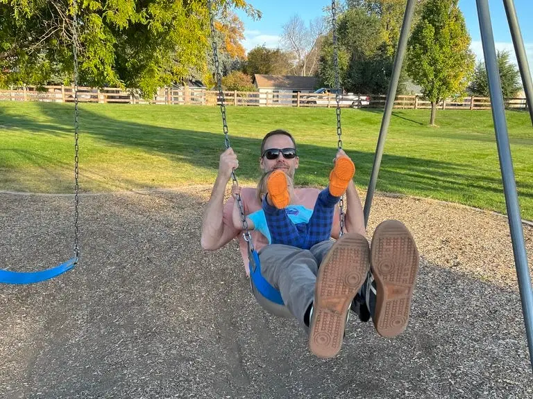 Father and daughter on a swing together.