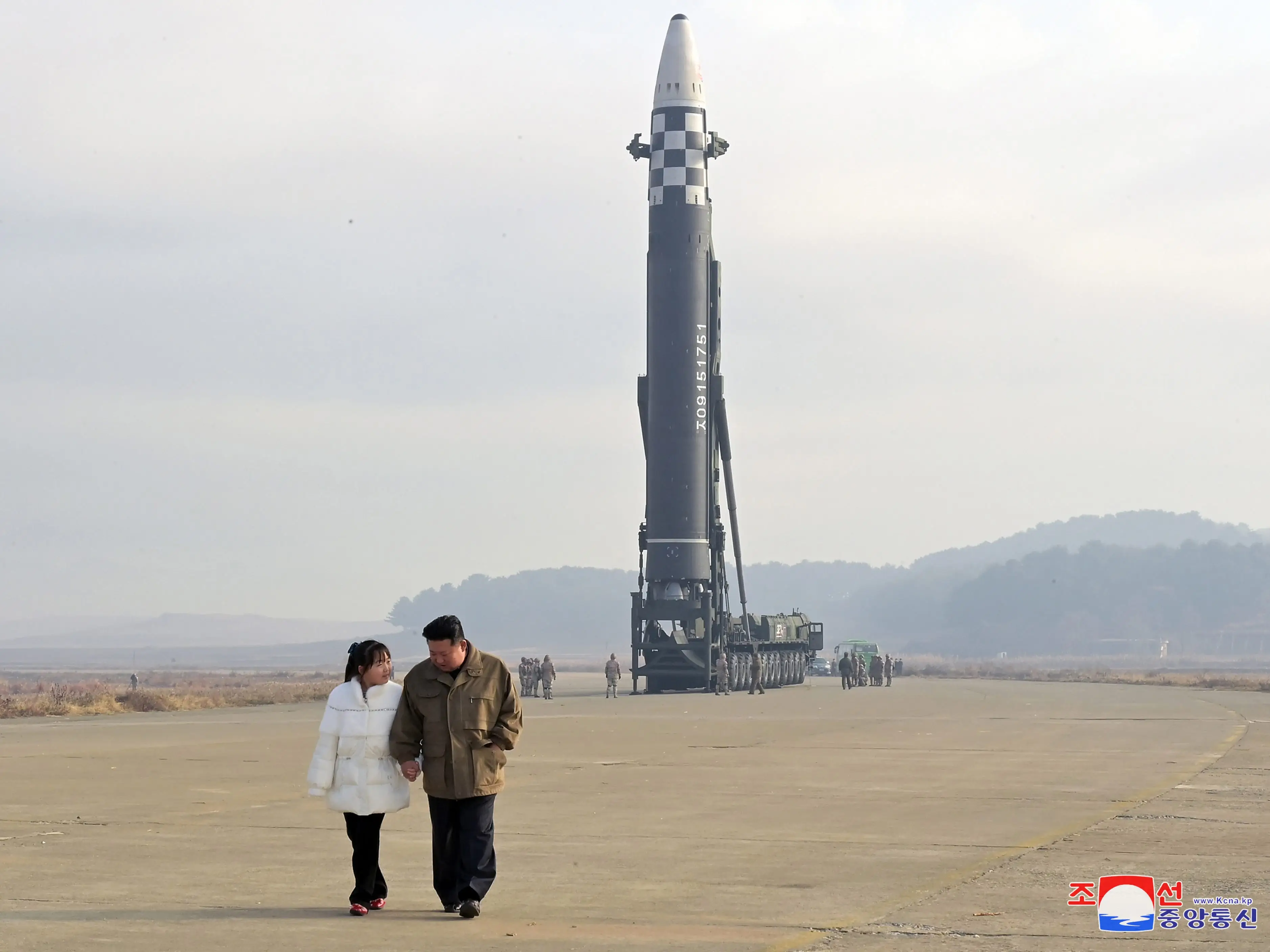 Kim Jong Un and Kim Ju Ae walking away from an ICBM.