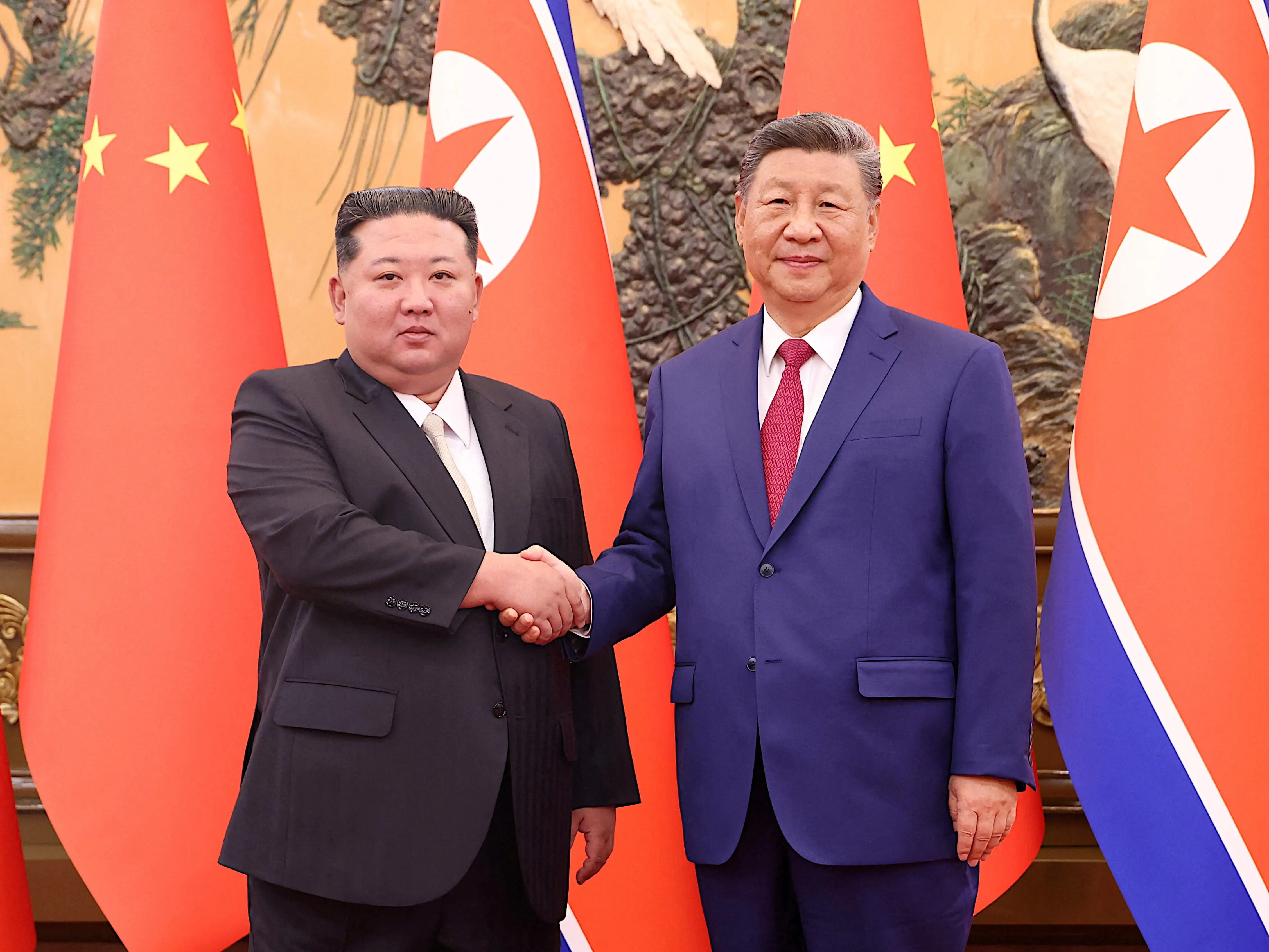 Kim Jong Un shakes hands with Chinese president Xi Jinping. Kim Ju Ae joined her father on the international trip.