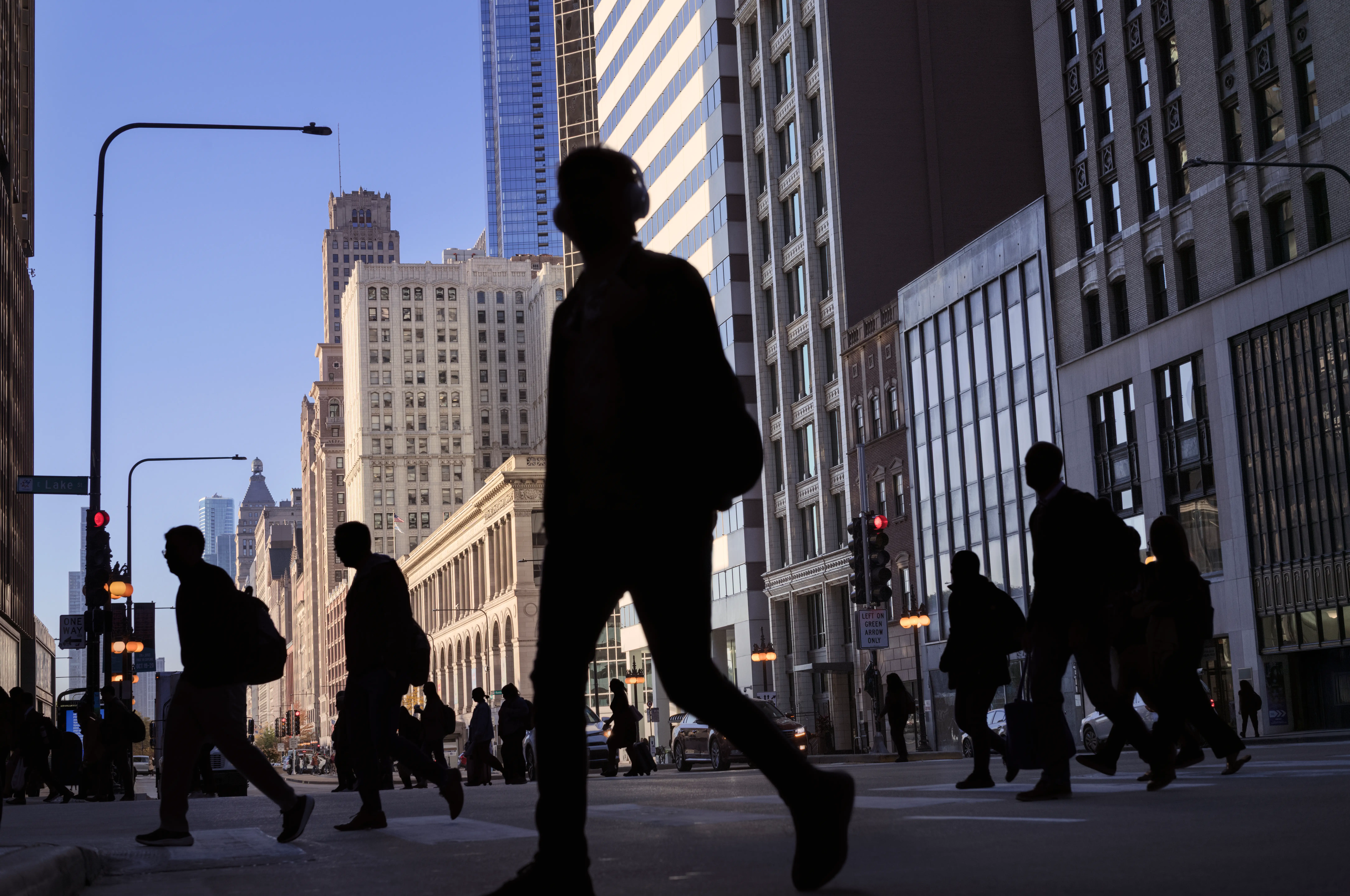 Silhouettes of workers crossing the street in a metropolitan area